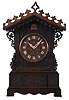 Johann Baptiste Beha, Germany, for Camerer, Kuss & Co., shelf cuckoo, architectural walnut case with inset panels containing carved trailing vine and leaf ornament, carved buttress corners, and repeating carved fleur de lys trim above and below gable, wooden dial with applied Roman numerals, with protective glass set in a brass bezel, pierced bone hands, full bodied wooden bird, large 8 day, time and strike fusee movement with brass plates, brass pendulum, case back with Camerer, Kuss & Co. label