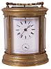 Switzerland, hour repeating carriage clock, oval case with beveled glasses and acanthus engraved top and base molding, Roman numeral, white enamel dial with subsidiary alarm chapter, blued steel Breguet style hands, 8 day time, strike, and alarm movement with lever platform, counting the hours on a gong, and repeating on demand, strike work planted on back plate, gong and hammer behind dial, and alarm bell in the base