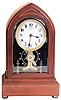 Eureka Clock Co. Ltd., London, England, battery powered mantel clock with oversized balance wheel movement in an inlayed mahogany case with beveled glasses and cream porcelain dial, s#9078