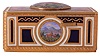 Karl Griesbaum, Germany, singing bird box, the box sides with blue and white champleve enamel framing colorful landscape scenes, the top featuring 3 figures in antique costume, relaxing in a garden, the woman on a swing suspended from a large tree, the front with sliding button to activate the multicolored bird, 20th century