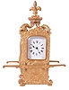 France, for Maple & Co., London and Paris, hour repeating carriage clock in the form of a sedan chair, the gilt brass case with rococo style ornament with plaques featuring naughty putti, scrolls, and shells, case sides with carrying handles, the top with scrolled brackets supporting a fleur de lis finial, and with well executed portrait of a young woman, behind glass at right side, Roman numeral white enamel dial, 8 day time and strike movement with lever platform, counting the hours on a gong, and repeating on demand, movement signed
