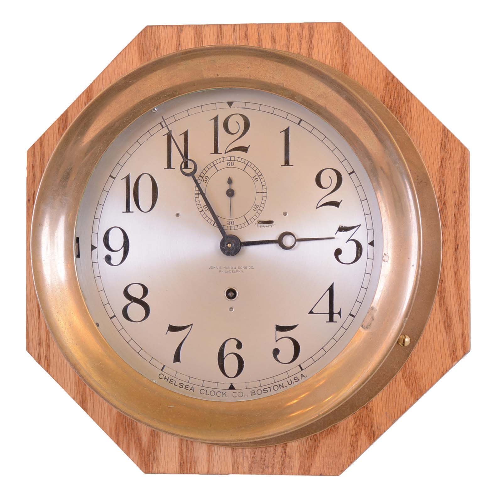 Chelsea Clock Co., Boston, Mass., for John E. Hand & Sons, Co., Philadelphia, brass case hinged bezel 8" dial time only engine room clock, #165517 shown in Demeter book as completed 4 / 29 / 25, mounted on newer octagonal oak board — Antique Clocks Price Guide