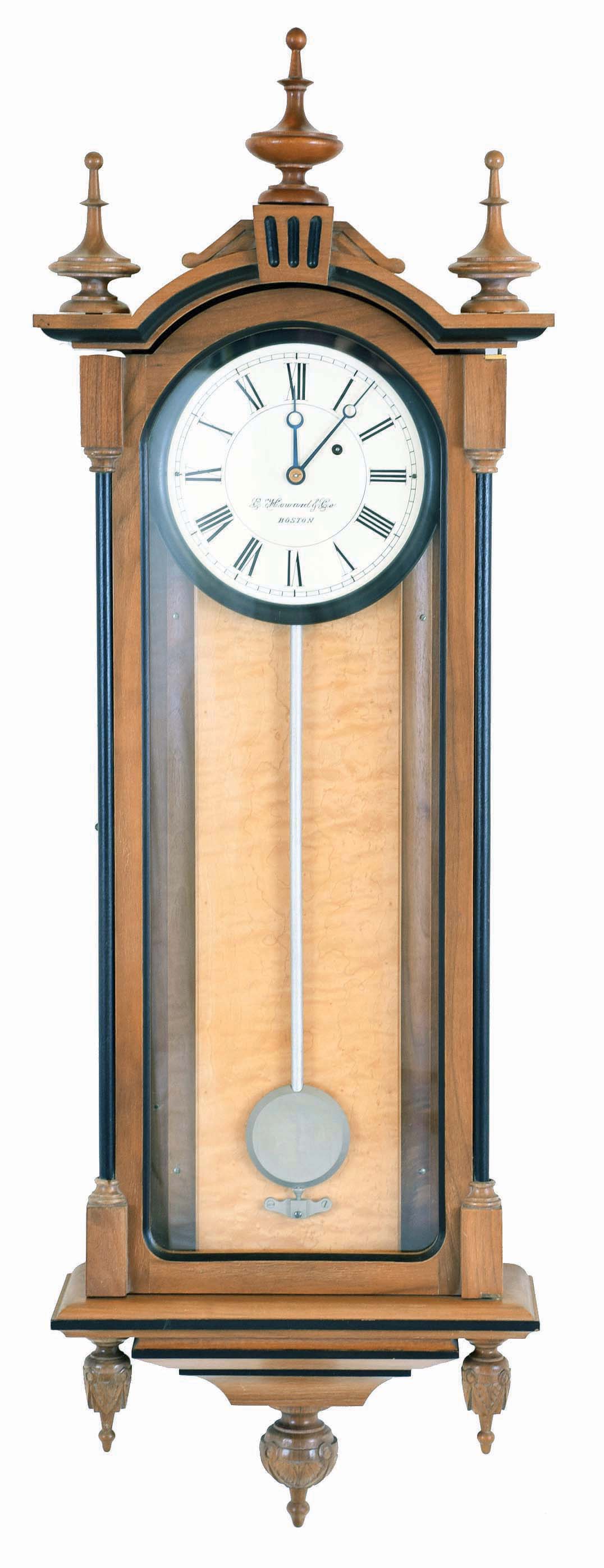 E. Howard & Co., Boston, Mass., "No. 59- 8 Regulator" reissue. Walnut case with ebonized moldings, turned and carved finials, curly maple weight baffle, ebonized wooden bezel with Roman numeral white painted 8" dial, blued steel moon hands, nickel pendulum with silver painted wooden rod, 8 day weight driven timepiece movement, The clock has serial number 275 on the movement and the case and is dated October, 1976. — Antique Clocks Price Guide