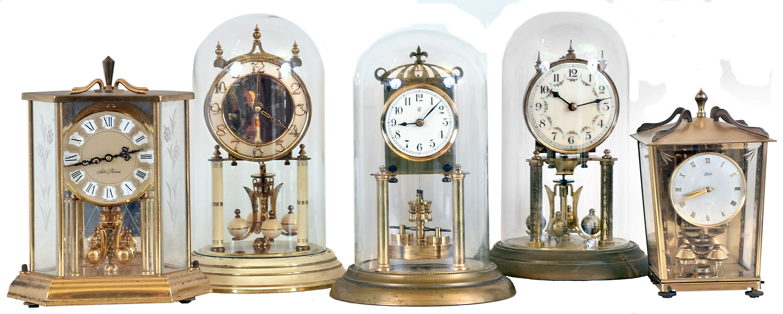 Clocks- 5 (Five) German 400 day brass and glass or "anniversary" clocks: Badiche with disk pendulum, early 20th century; later square carriage- style Schatz; 6 size Seth Thomas; Kieninger with white painted areas and original paperwork; floral enamel dial — Antique Clocks Price Guide