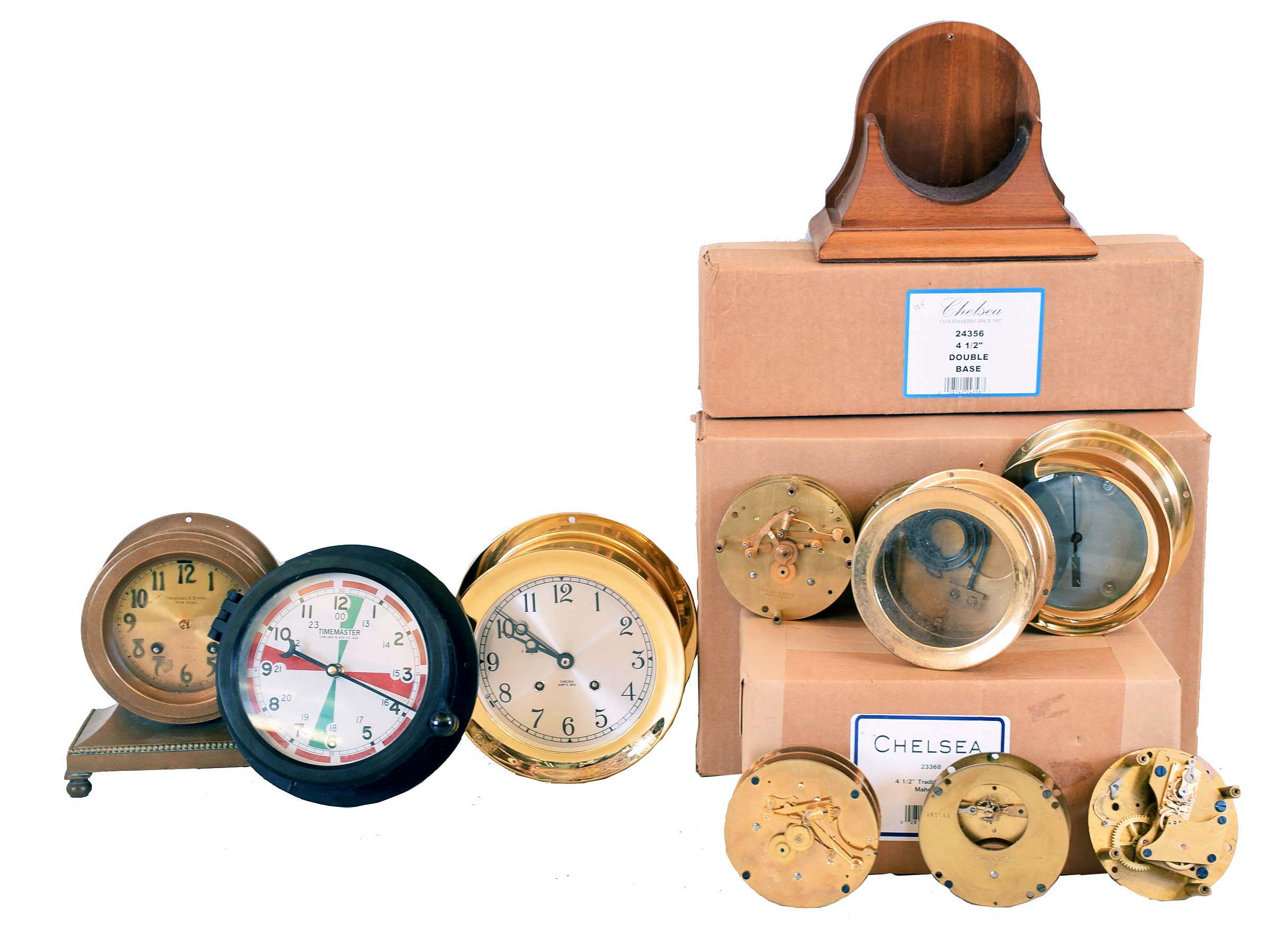 Clocks and Parts, Chelsea Clock Company: 5 movements, 3 ship's bells, 2 time only; Timemaster quartz radio room in black phenolic case; "Library" with applied bronze numbers; 6 inch ship's bells with missing balance platform; 4 wood stands; quartz movement ship's bells with no dial or hands; case only for 4 inch ship's bells movement — Antique Clocks Price Guide