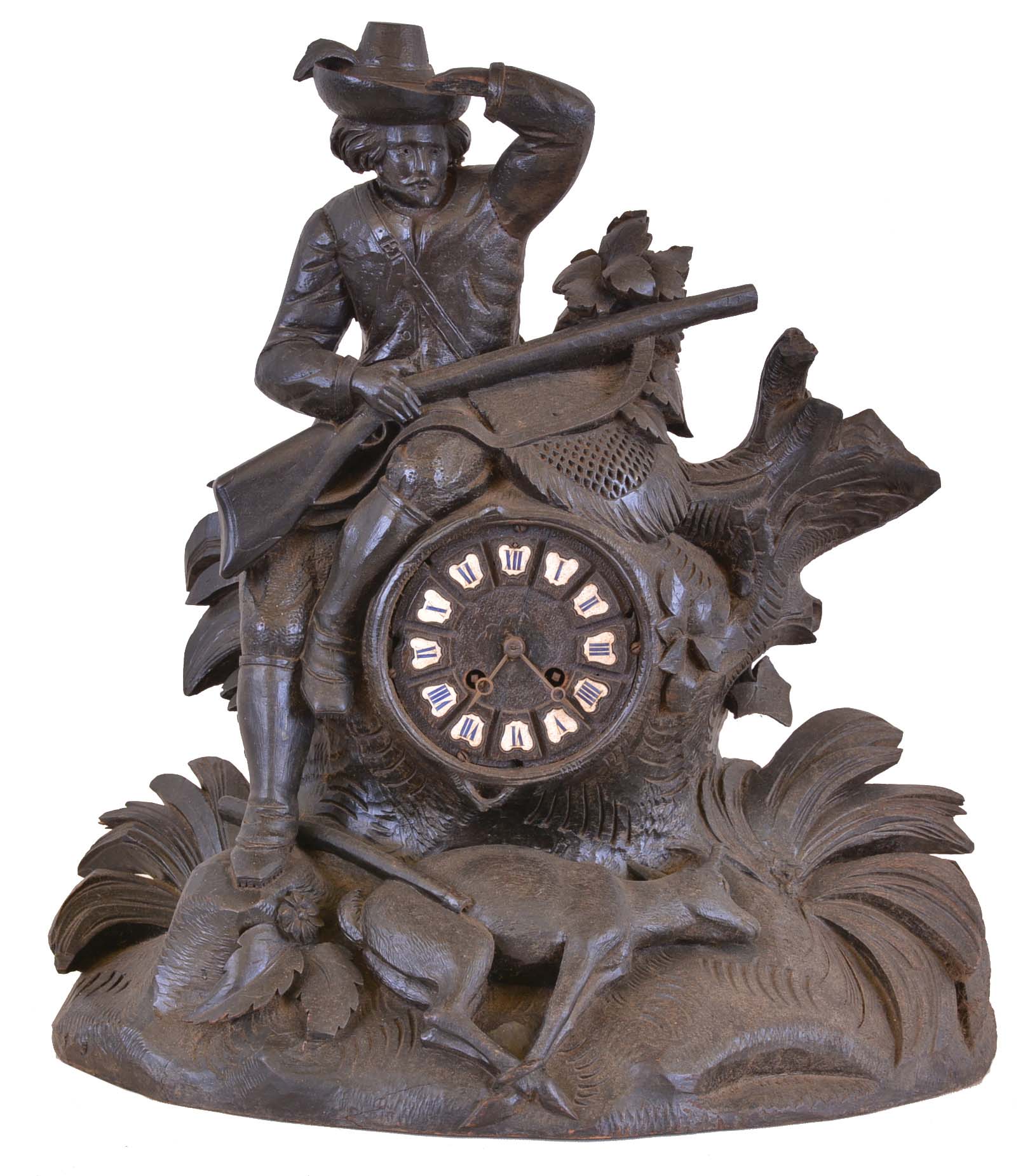 Germany, a large black forest figural mantel clock, the case with seated hunter scanning the horizon, (perhaps waiting for a bus), with carved stump, rocks, foliage, and kill at his feet, wooden dial with applied Roman numeral cartouches, blued steel Breguet style hands, 8 day time and strike pendule de Paris movement — Antique Clocks Price Guide