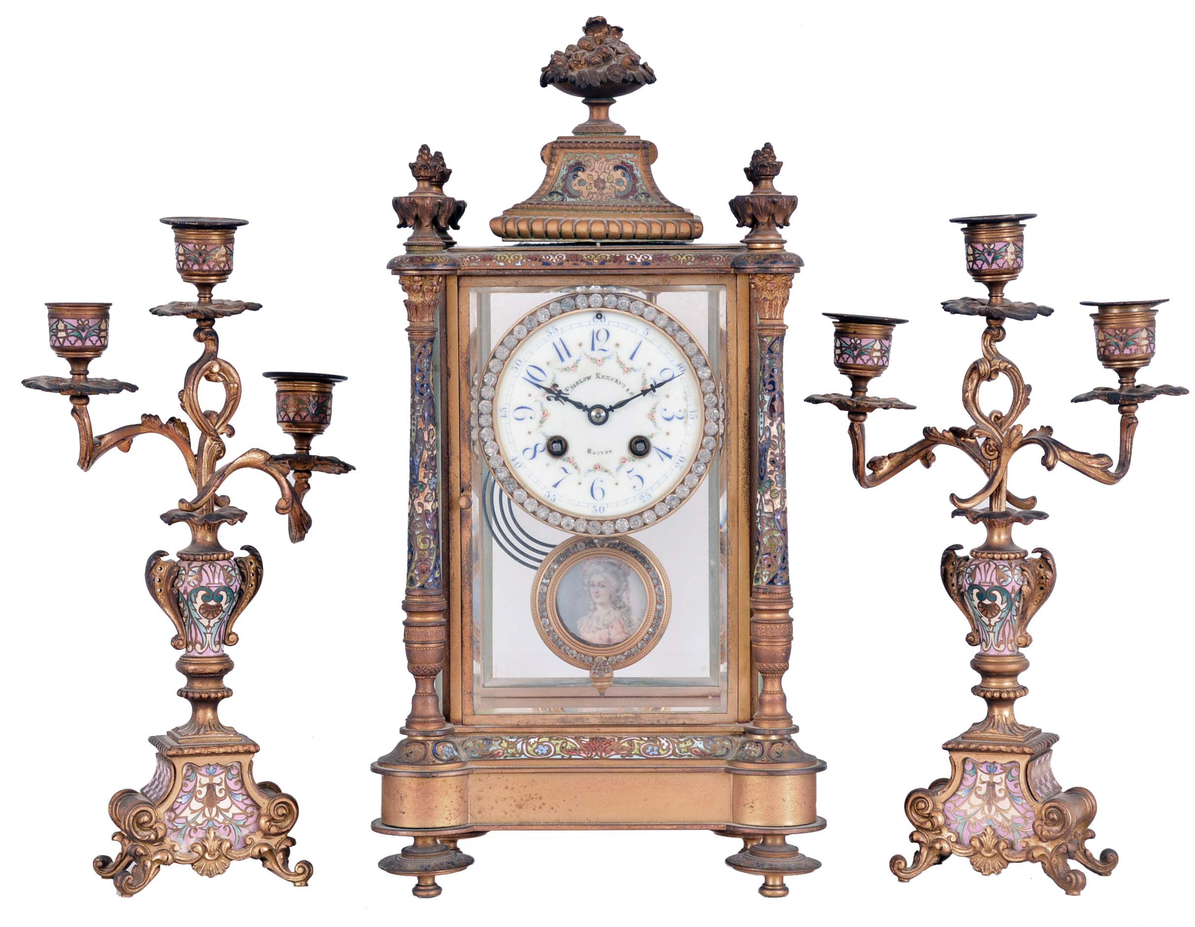 France, for Bigelow, Kennard, & Co., 3 piece mantel garniture, ornate gilt and champleve enamel crystal regulator, Arabic numeral numeral enamel dial with floral garlands, blued steel hands, and brilliant set bezel, 8 day time and strike pendule de Paris movement, gilt, brilliant set pendulum with signed portrait of a young woman, the side pieces each holding three candles, and with gilt and champleve enamel ornamented surfaces — Antique Clocks Price Guide