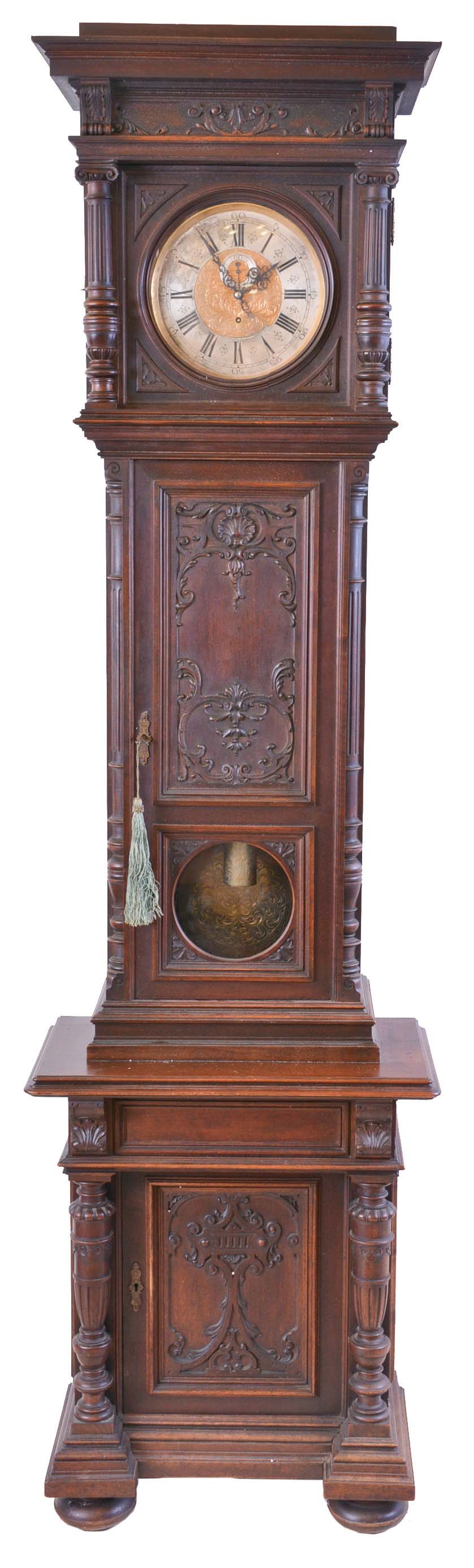 V. Postpischil, Vienna, Austria, long duration tall clock, 30 day, time only, weight driven movement in a carved walnut case with glazed window for engraved pendulum bob, bun feet and cabinet in base. The brass dial has silvered chapter ring is signed by maker and engraved center with matching engraved weight. — Antique Clocks Price Guide