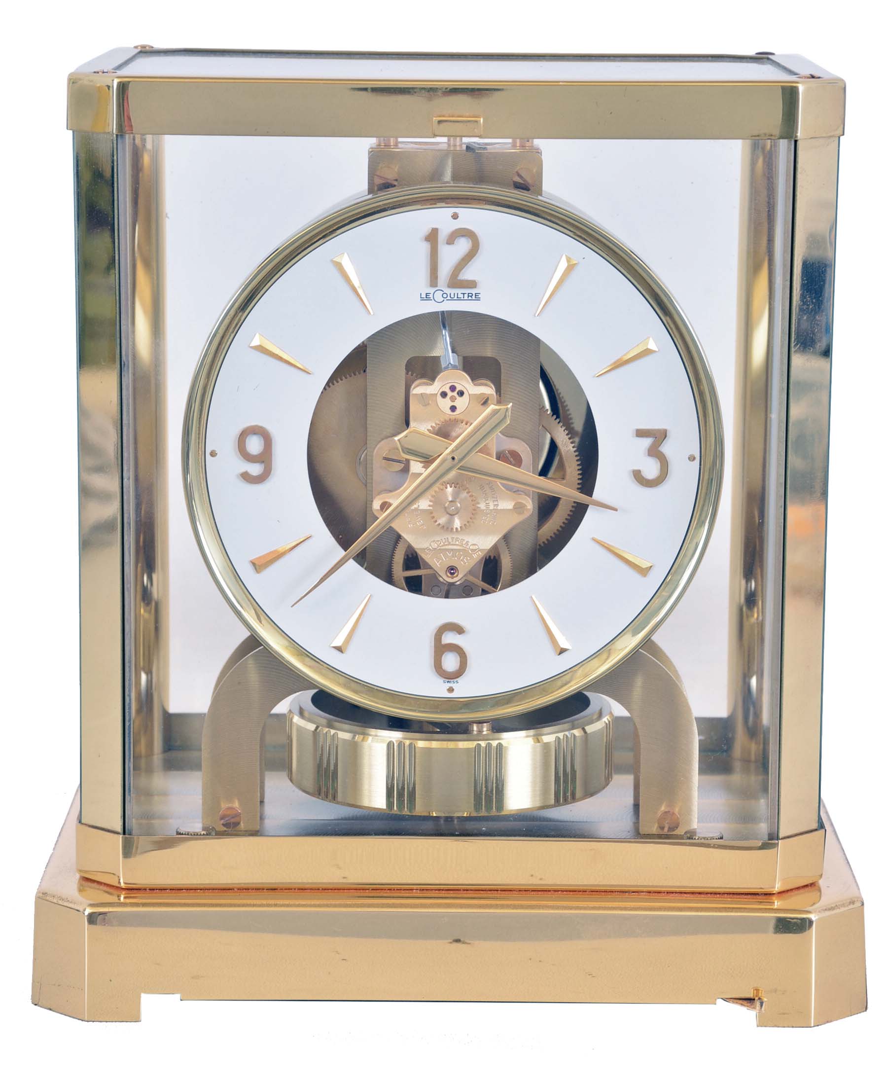 LeCoultre & Cie, Switzerland, "Atmos" clock, 15 jewel gilt caliber 528 movement, gilt torsion pendulum, round white painted dial with applied gilt Arabic numerals and arrow markers, gilt hands, contained in a glazed rectangular case with removable front panel, serial #224079 — Antique Clocks Price Guide