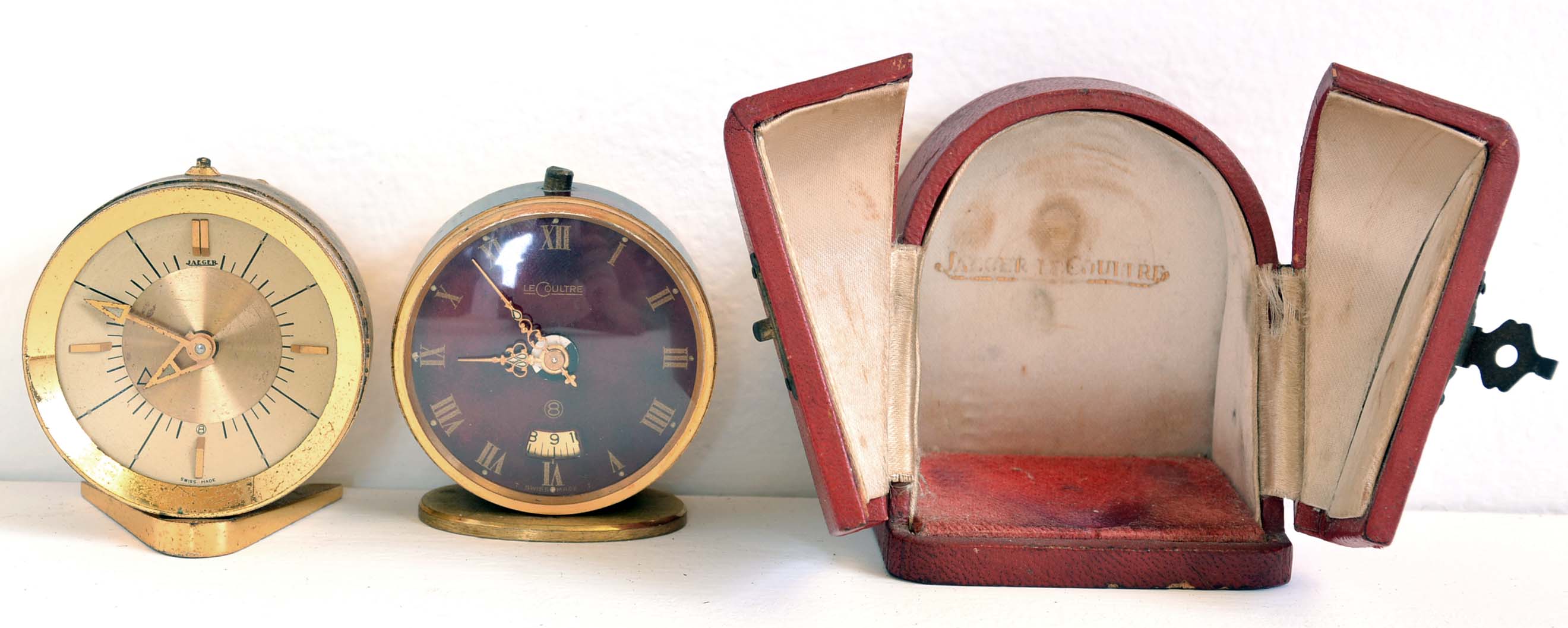 LeCoultre, Switzerland, two travel alarm clocks, one with red morocco case and convex dial, the other with red painted case and dial, both with lever escapements and alarms — Antique Clocks Price Guide