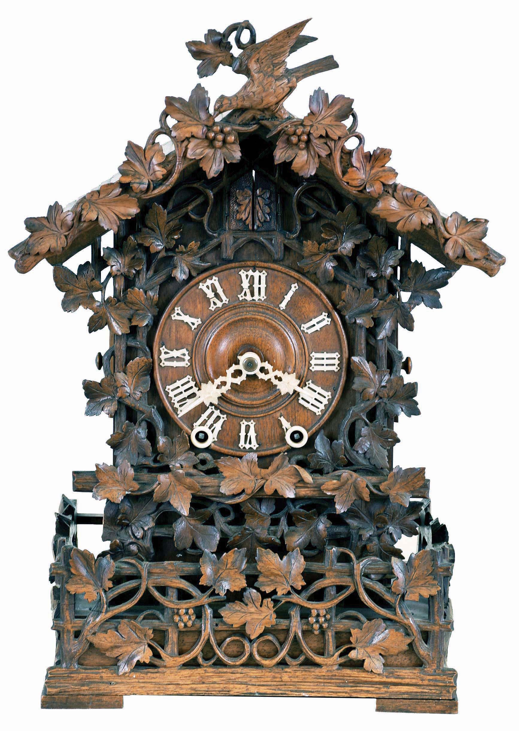 Johann Baptist Beha, Eisenbach, model 512 shelf cuckoo, nicely carved case with rustic railings covered in vines, roof with individually carved shakes and also trimmed with rustic ornament, vines, and a carved bird, Roman numeral wooden dial, pierced and carved bone hands, full body carved and painted cuckoo, 8 day, time and strike fusee movement with wooden plates, case back with the label of Camerer, Cuss & Co. — Antique Clocks Price Guide