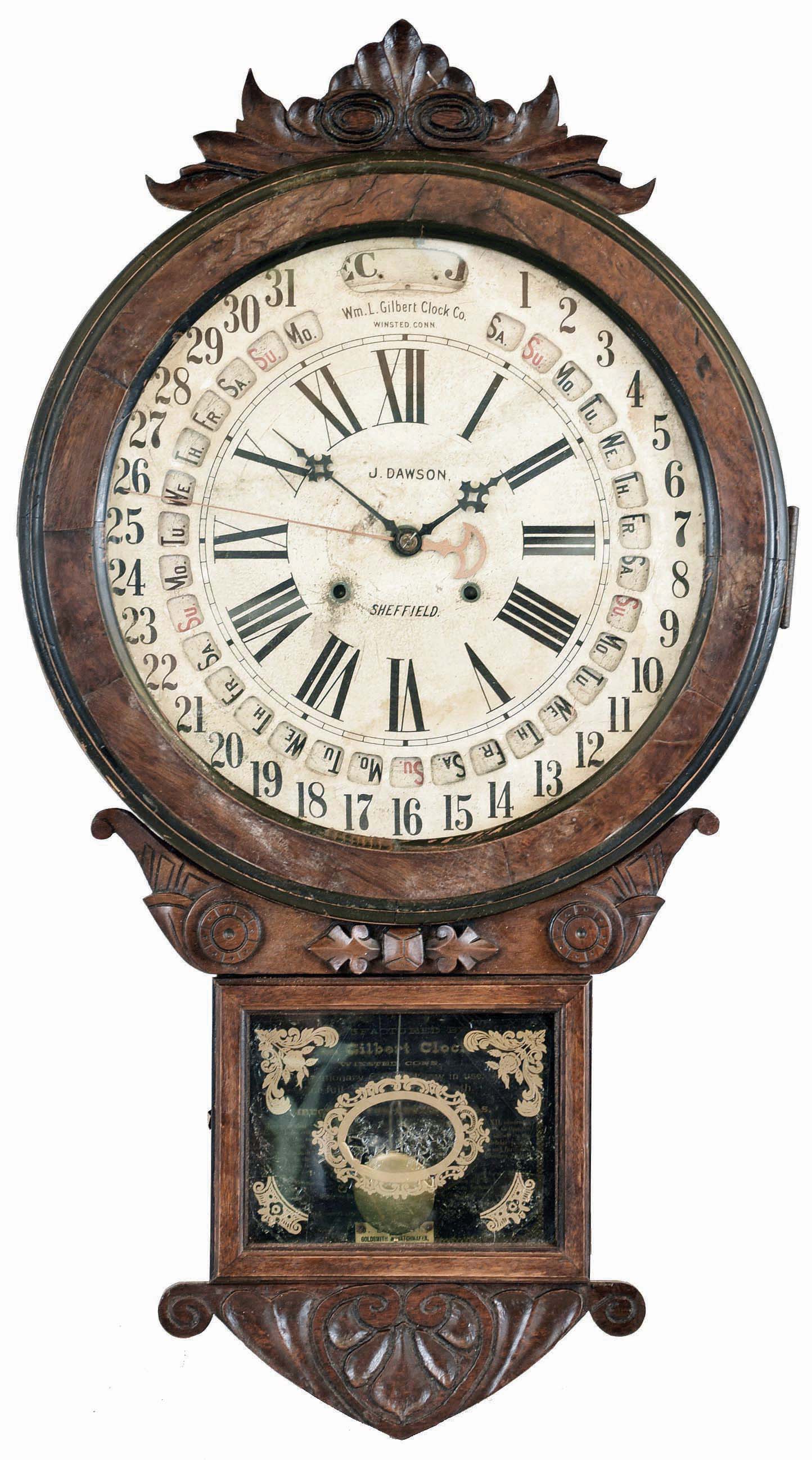 William L. Gilbert Clock Co., Winsted, Conn., "Office Drop Calendar" wall hanging clock with an 8 day spring driven time and strike movement with Gilbert's simple calendar mechanism in a walnut and burl walnut veneered case. — Antique Clocks Price Guide