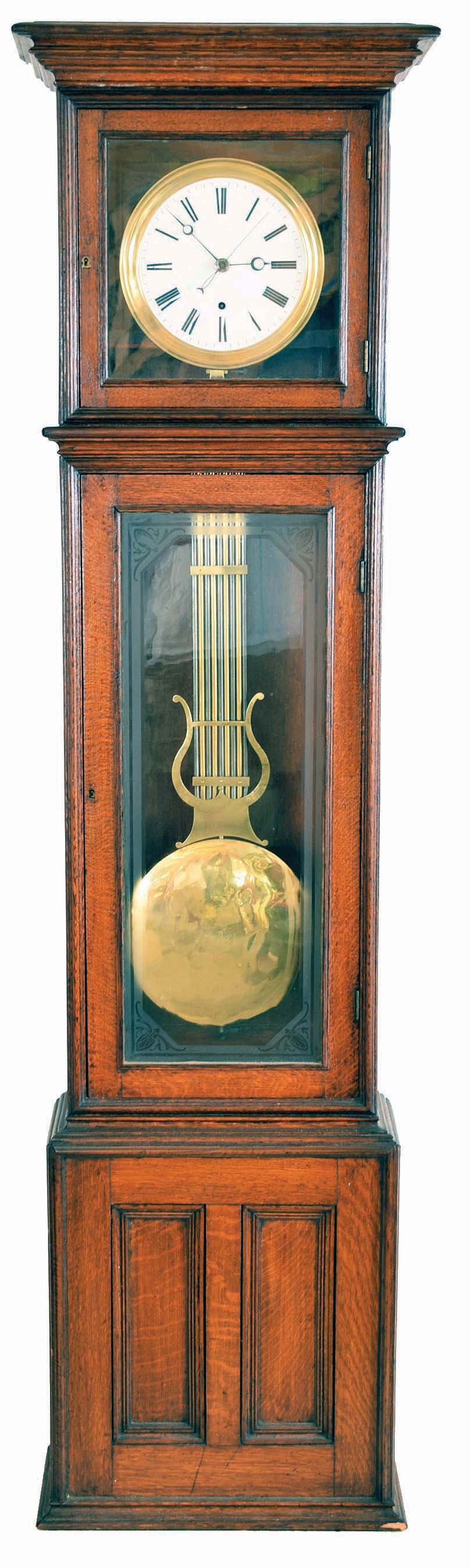 Standing jeweler's regulator, time only, 8 day, weight driven Swiss pinwheel movement with a gridiron pendulum in an oak case with glass front and white enamel dial. — Antique Clocks Price Guide