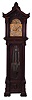 England tall clock with tubular bells retailed by Bigelow, Kennard & Co., 8 day, time, strike and chime on 9 tubular bells playing Westminster and one other tune, three brass weight driven movement in a mahogany case with pediment top and side and center carvings. The tympanum above the dial has applied carved moldings, the hood door has double columns on each side with carved volute capitals over the trunk with full columns flanking beveled glass door with carved volute capitals resting on a base with applied carved moldings and paw feet. The brass dial has applied brass numerals over a silvered chapter ring and silvered second's bit, ornately engraved spandrels and dial center, moon phase, strike / silent and tune selectors.