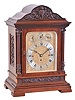 England, large bracket clock, polished mahogany architectural case, foliate carved panel above a molded, stepped base, fluted columns flanking the door, and supporting an egg and dart carved, molded cornice, the top with foliate carved paned and central mask, composite dial with gilt, engraved plate, silvered Roman numeral chapter ring with subsidiary dials for regulation and chime control, substantial three train fusee movement, and playing Whittington or Cambridge chimes at the quarters, and striking the hours on a large gong
