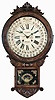 William L. Gilbert Clock Co., Winsted, Conn., "Office Drop Calendar" wall hanging clock with an 8 day spring driven time and strike movement with Gilbert's simple calendar mechanism in a walnut and burl walnut veneered case.