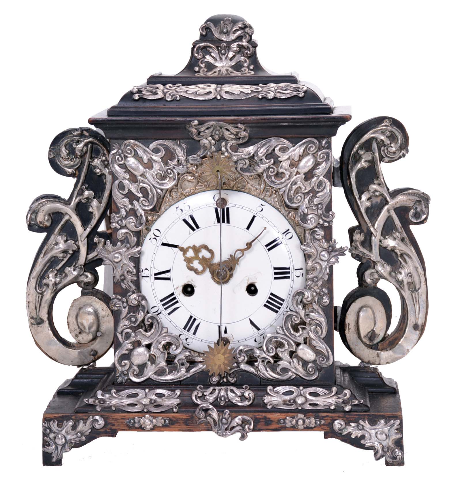 Europe, 18th century, bracket or shelf clock with cow tail pendulum, ebonized wooden case with applied moldings and laden with leaf and scroll, repousse silver ornaments, and case sides with applied scroll ornaments Roman numeral white enamel dial with raised chapter and concave center, fancy pierced and engraved brass hands, brass time and strike movement probably of two day duration, with verge escapement, and engraved, star shaped pendulum swinging in front of the dial — Antique Clocks Price Guide