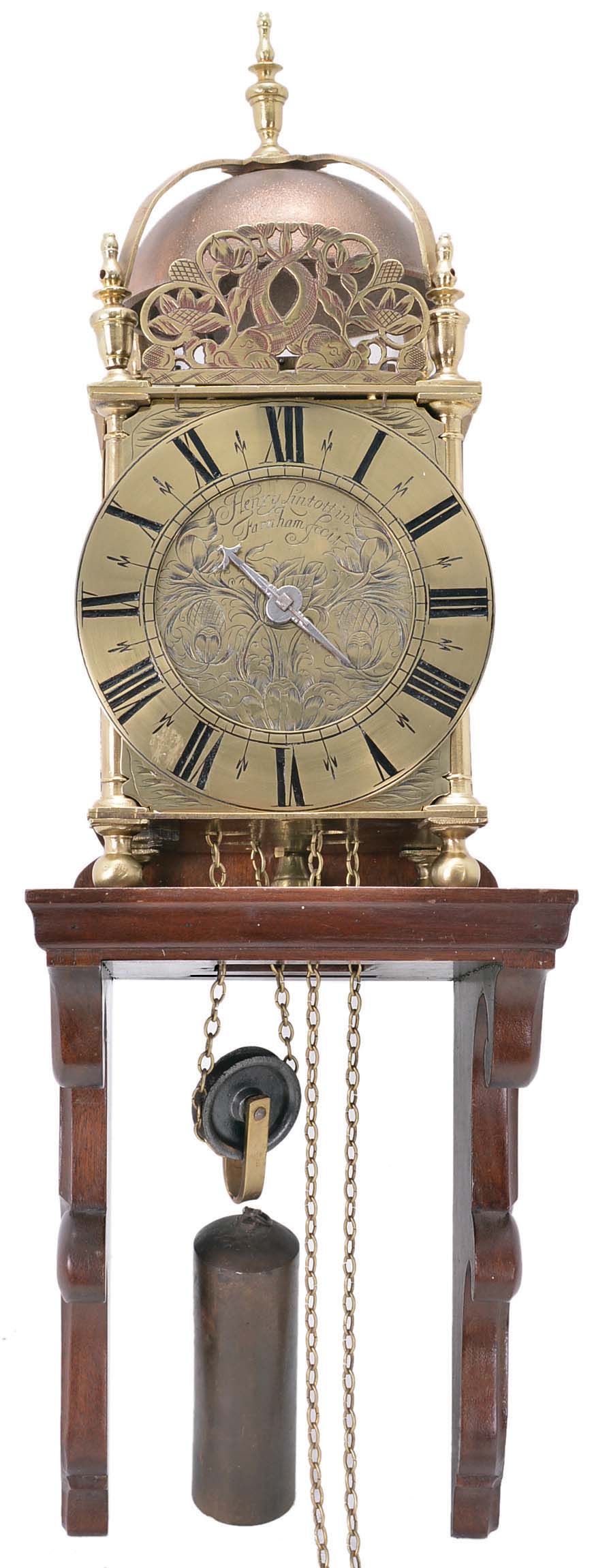 English lantern clock signed "Henry Lintott in Farnham, fecit." Brass case with turned columns, feet and finials, case front with pierced dolphin fret, top with brass bell cage and turned finial, engraved Roman numeral brass dial with engraved center and single, decorated steel hand, 30 hour brass movement with verge escapement and count wheel striking, and brass clad lead weight, together with a 20th century, purpose made bracket for hanging. Henry Lintott, age about 24, bachelor, of Farnham, Surrey, was granted a license to marry Mrs. Mary Mabberly, of Farnham, aged about 22, with consent of her mother, May 18, 1691. The will of Henry Lintott, Watchmaker, of Farnham, Surrey, was probated Apr. 14, 1705 in the Prerogative Court of Canterbury. — Antique Clocks Price Guide