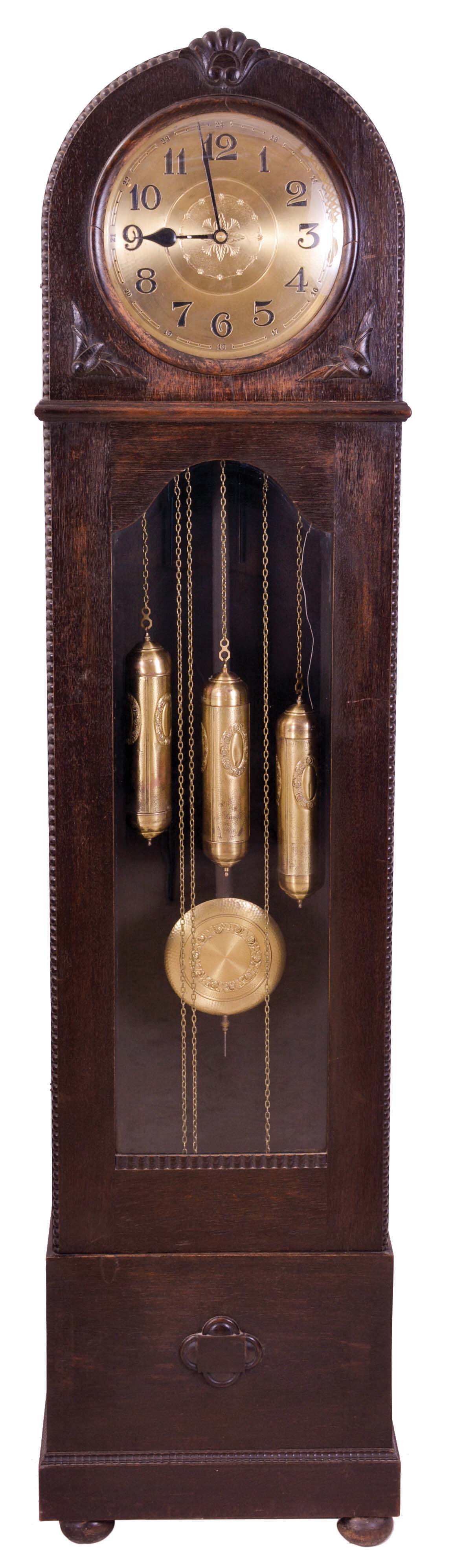 Germany, tall clock, 8 day, time, strike and chime on gongs, three embossed brass weight driven movement with matching pendulum bob in a dark oak case with beveled glass door and round top with convex glass and brass dial — Antique Clocks Price Guide