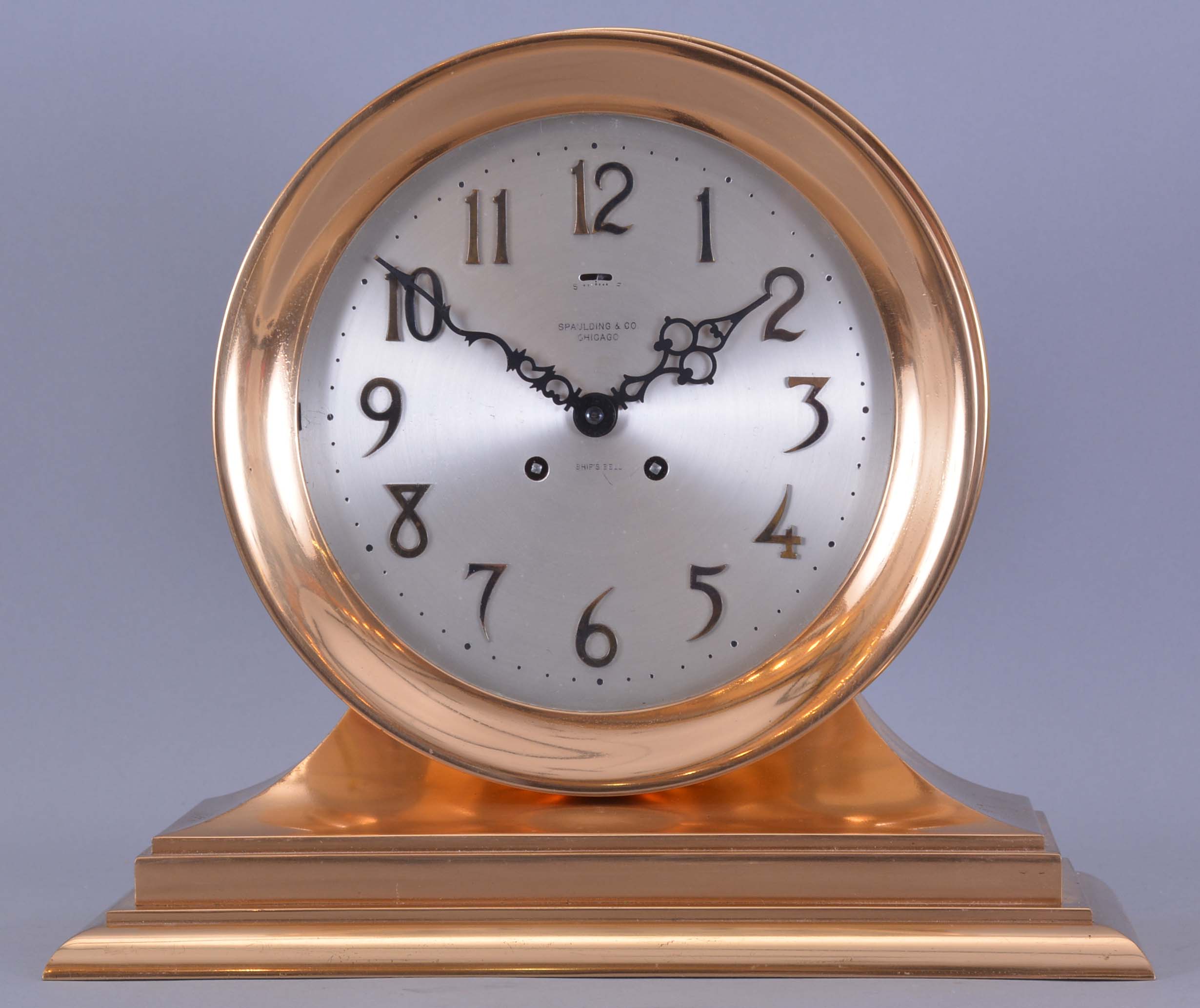 Chelsea Clock Co., Boston, Mass., retailed by Spaulding & Co., Chicago, "Commander" on metal base with 8 1/2" special dial, 8 day, spring driven, time and ship's bell striking movement in a polished brass case mantel clock — Antique Clocks Price Guide