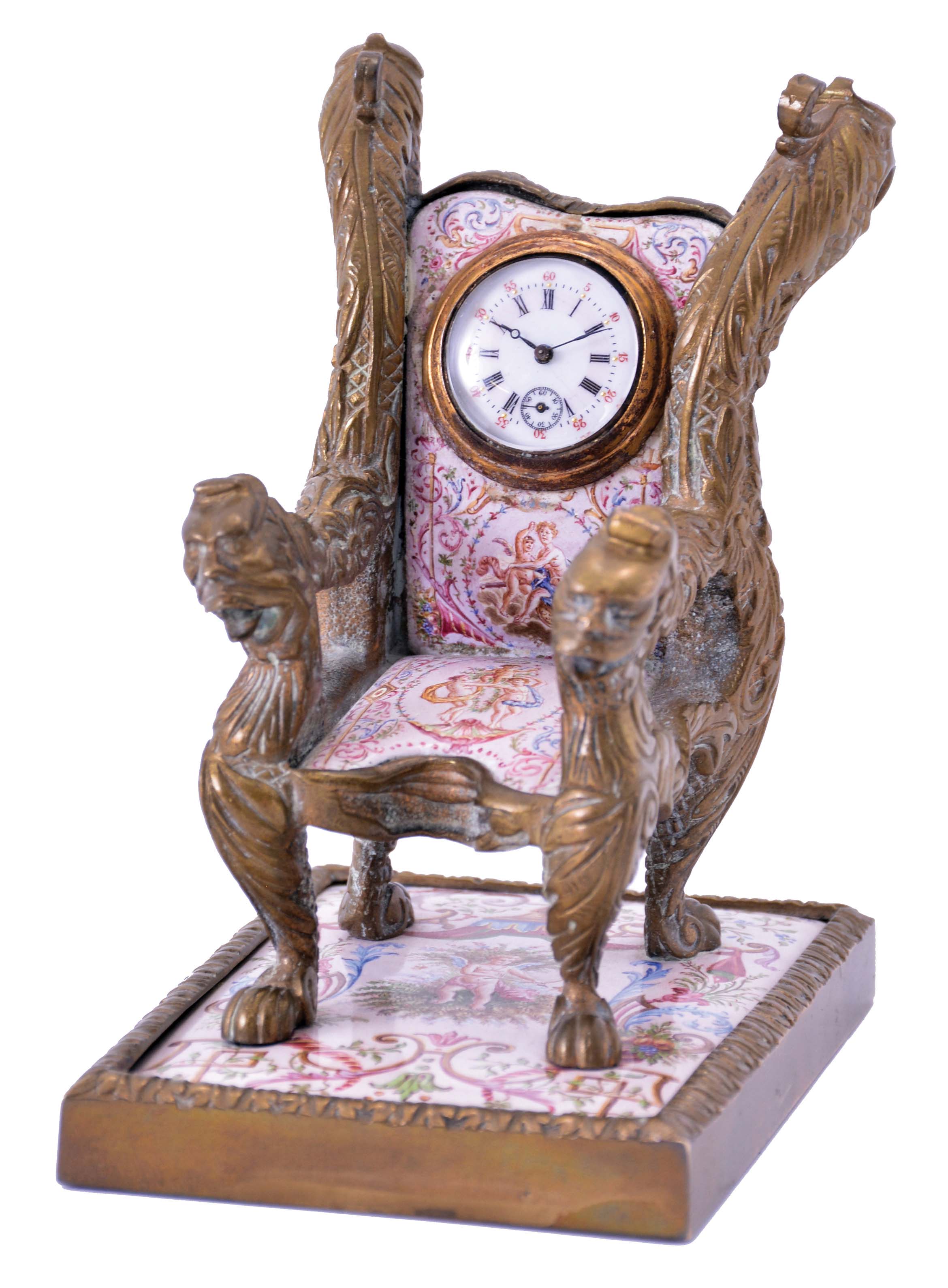 Viennese armchair form desk clock, cast brass case set with polychrome enamel panels, the casting with foliate ornament and griffin heads at upper back, and arms with the heads of other mythical beasts, enamel panels done in typical 19th century Viennese style, with figures, and classical ornament, the chair back set with a 30 hour key wound timepiece — Antique Clocks Price Guide
