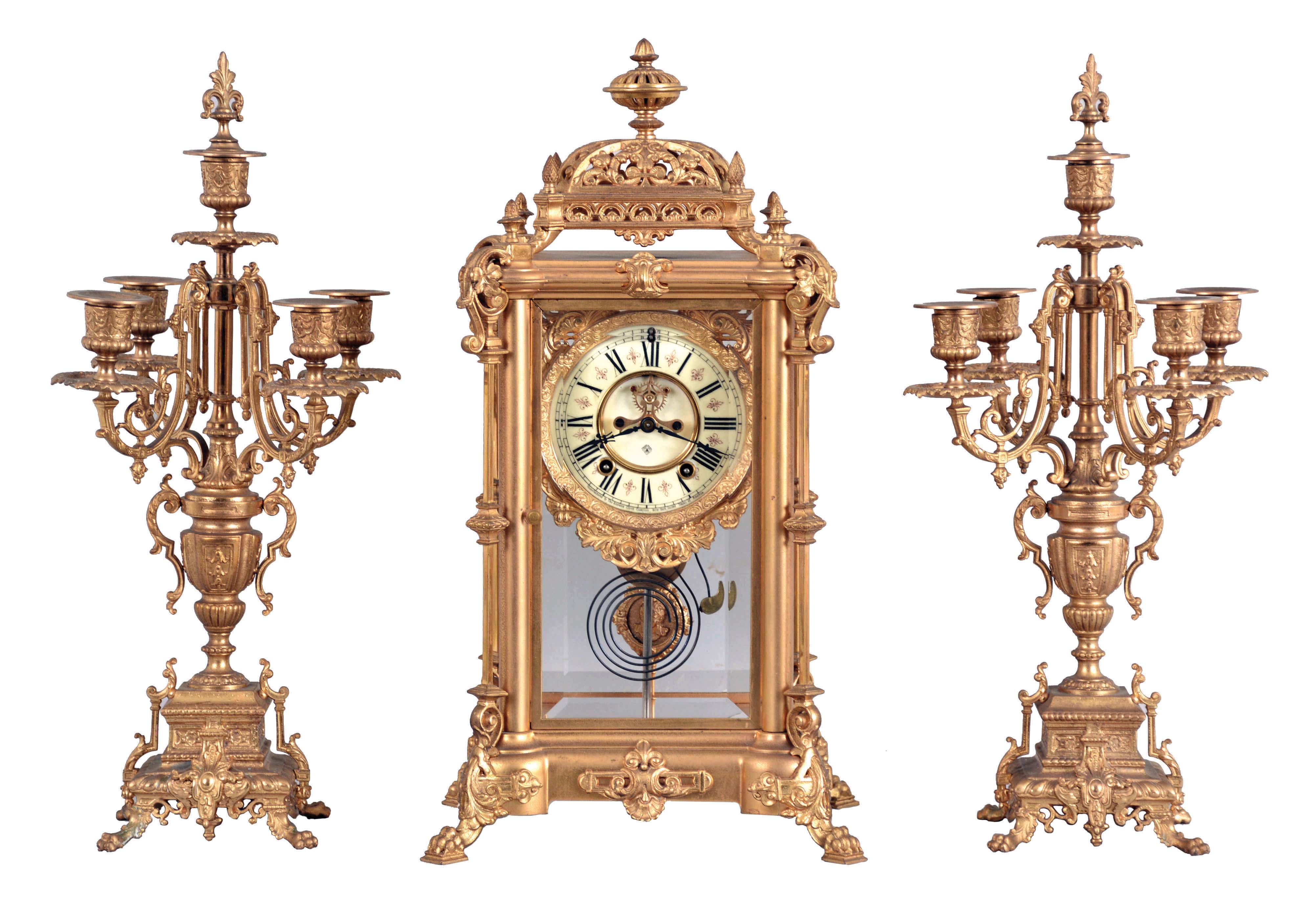 Ansonia Clock Co., New York, NY, "Excelsior" Crystal Regulator with two matching candelabra (No. 1110) with a spring driven, 8 day time and half hour strike movement (rack & snail strike) in a gilt finished brass case. — Antique Clocks Price Guide