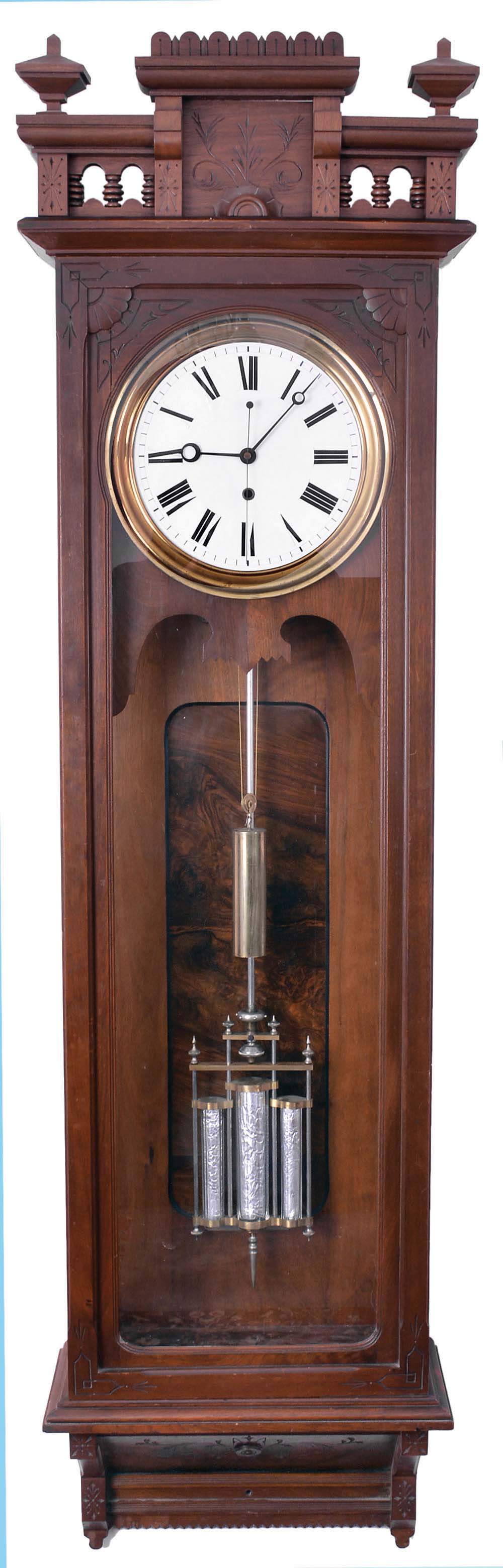 Wm. L. Gilbert Clock Co., Winsted, Conn., "Regulator No. 18", jeweler's regulator wall clock, the mahogany case with burl mahogany panel, Roman numeral white enamel dial, blued steel hands, 8 day, time only, weight driven movement with three jar mercury pendulum, deadbeat escapement and maintaining power — Antique Clocks Price Guide
