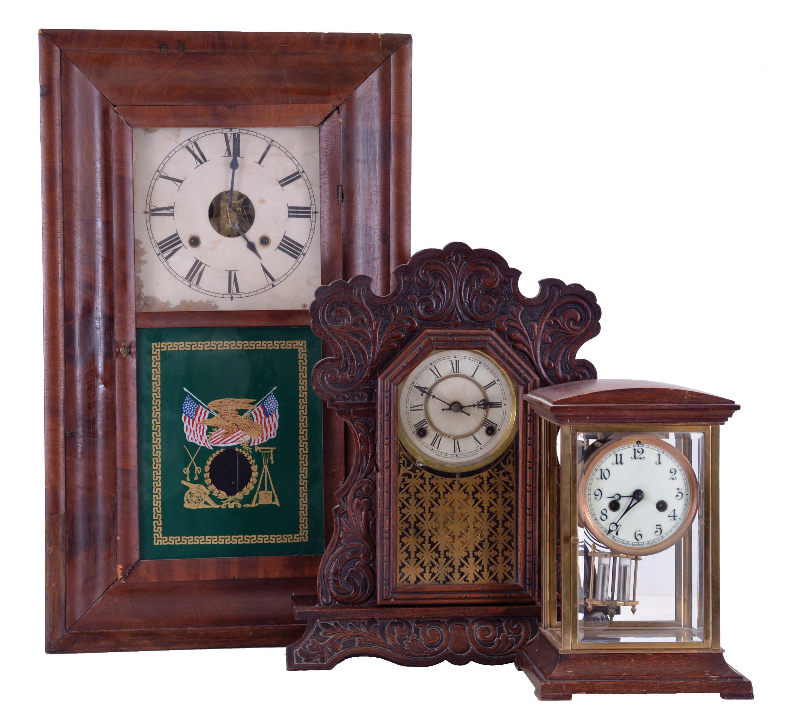 Clocks- 3 (Three) American Mantel: (1) Waterbury Clock Co., Waterbury Conn., crystal regulator, 8 day time and strike, spring driven movement with simulated mercury pendulum in case with wooden top and bottom; (2) Waterbury Clock Co., Waterbury Conn., "Unity", 8 day time and gong strike, spring driven movement shelf clock in a walnut case; (3) William S. Johnson, NY, OOG mantel clock, unsigned 30 hour time and strike weight-driven movement in a mahogany veneered case. — Antique Clocks Price Guide