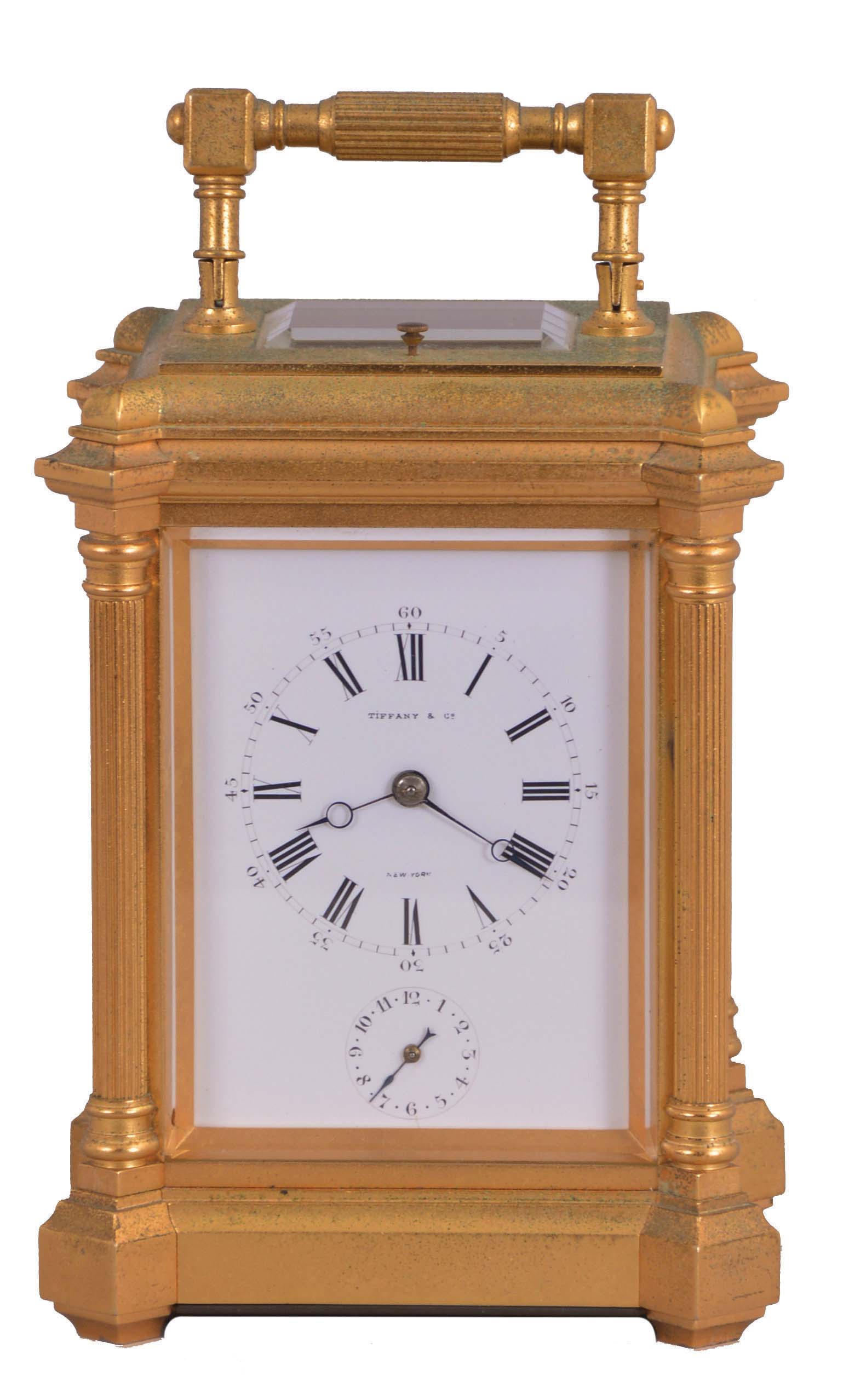 France, for Tiffany & Co., New York, hour repeating carriage clock with alarm, the glazed, the gilt, architectural case with projecting corners, fluted columns supporting a molded cornice, and a conforming, ovolo molded top with carrying handle, Roman numeral white enamel dial with subsidiary alarm chapter, blued steel Breguet style hands, and 8 day, time and strike movement with lever platform, striking the hour and half hour in passing, and repeating the last hour on demand, serial #3130, dial and movement signed — Antique Clocks Price Guide