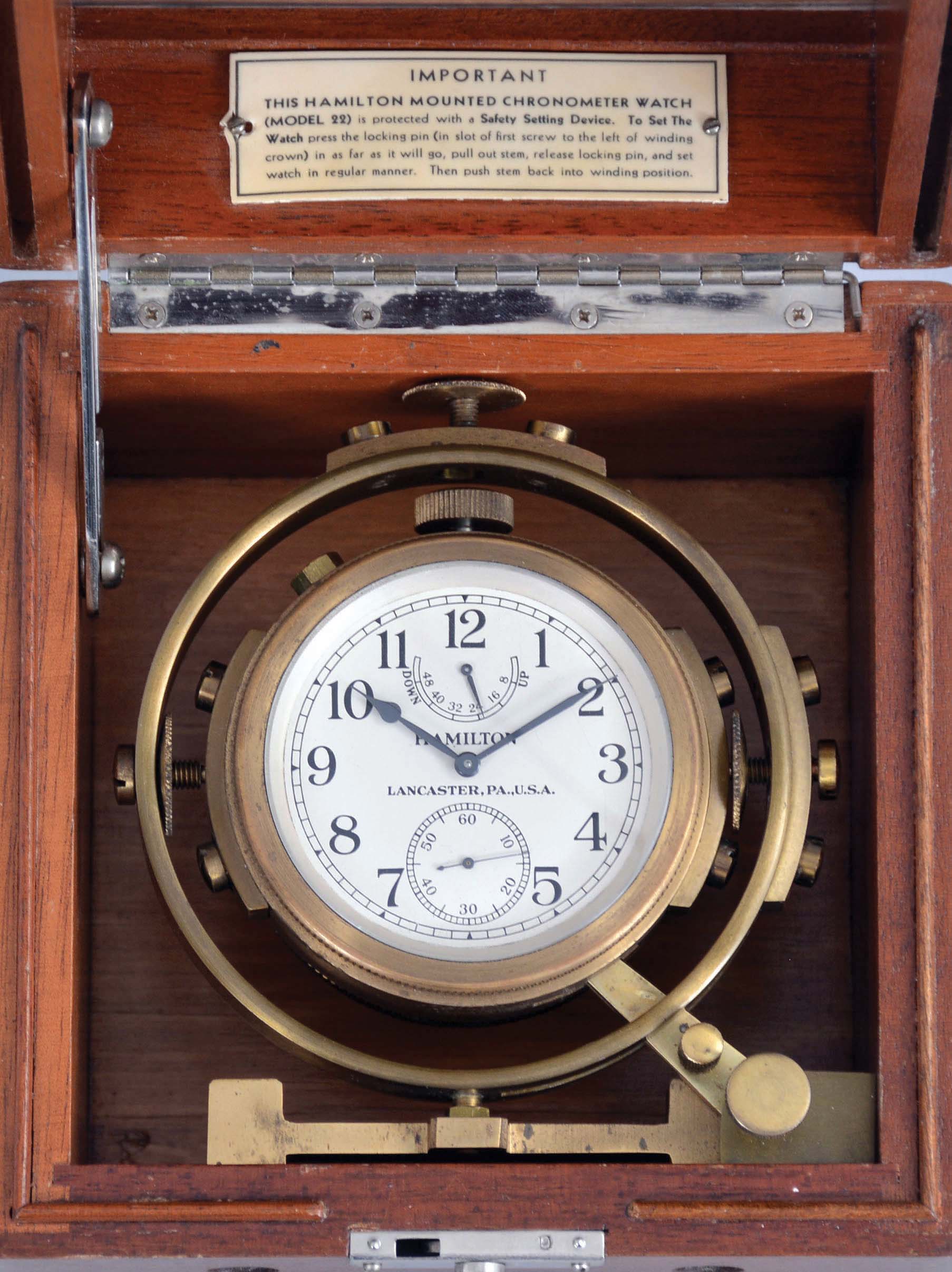 Hamilton Watch Co., Lancaster, Penn., model 22 chronometer watch with wind indicator, 35 size, 21 jewels, stem wind, pin set, adjusted to 6 positions and temperature, straight line damascened nickel plate movement, with lever escapement and micrometric regulator, Arabic numeral silvered metal dial, black steel spade and poker hands, the timepiece contained in a gimbaled bowl, and mounted in a mahogany box, movement marked "U.S. Navy Bu. Ships - 1942", serial #2F9086 — Antique Clocks Price Guide