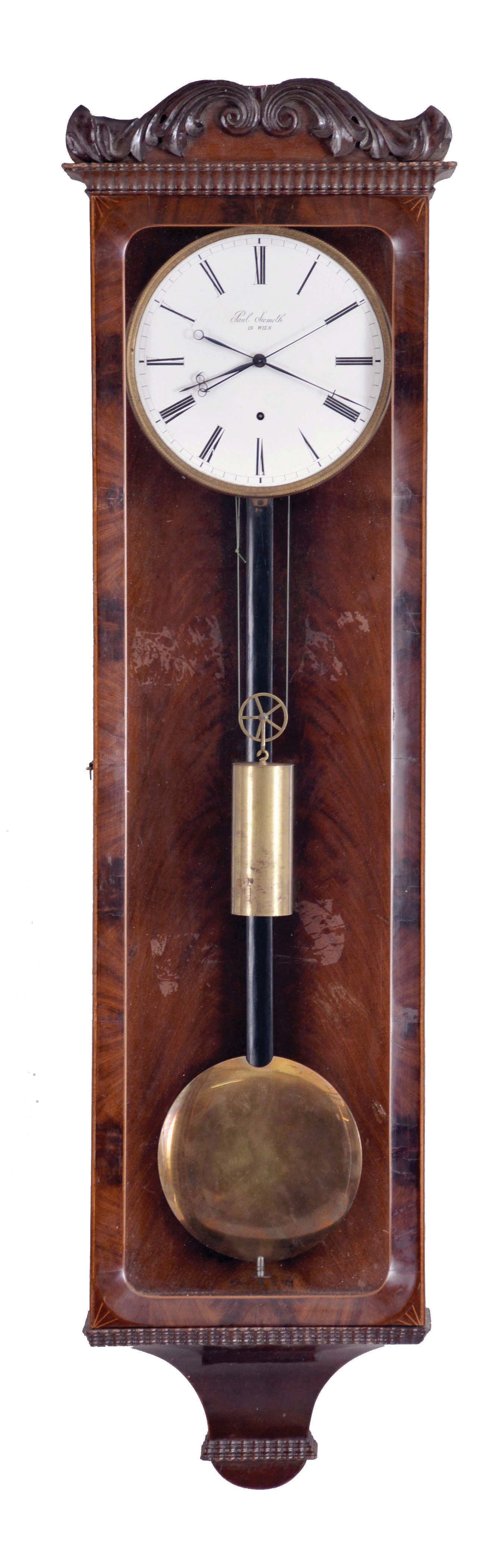 Paul Siemeth, in Wien, 30 day hanging regulator timepiece with sweep seconds in the Biedermeier style, rectilinear, 5 light, mahogany veneered case with boxwood stringing, beveled door, incurved bottom bracket with ripple moldings, and ripple molded cornice, case top with applied foliate carvings, signed Roman numeral white enamel dial, blued steel hands, cylindrical brass weight, and pendulum with ebonized rod and brass bob — Antique Clocks Price Guide
