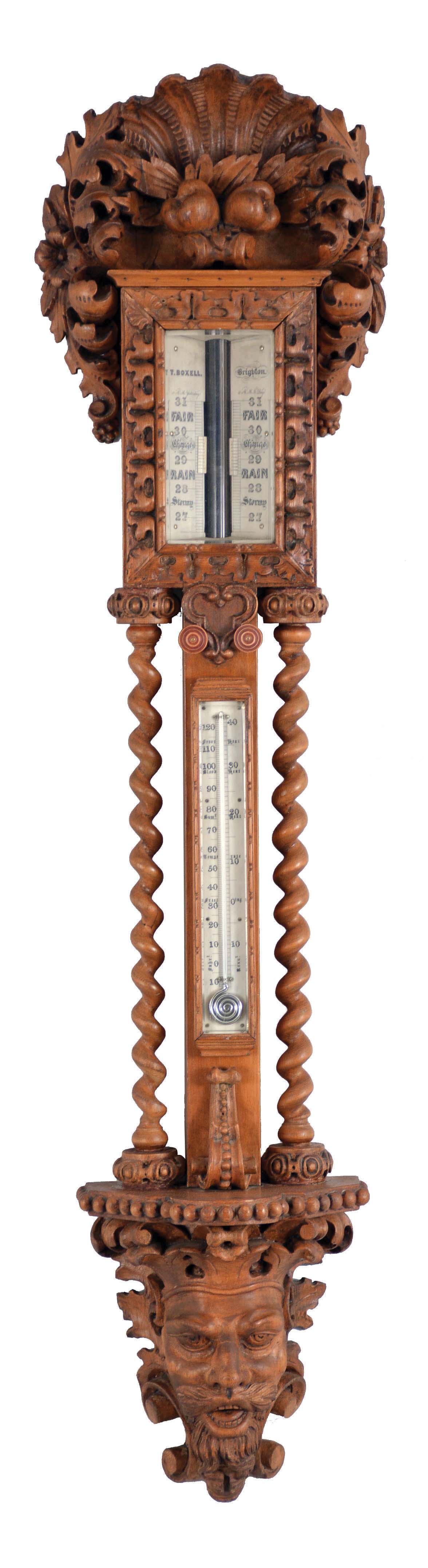 T. Boxell, Brighton, an ornately carved softwood barometer, the base with "green man" mask, trimmed with foliate ornament, beneath a shelf with barley twist columns flanking a thermometer with engraved reamur and fahrenheit scales, the top with engraved barometer scales surrounded by carved trim, and surmounted with a large, removable top carved with scallop shell, fruit and leaves — Antique Clocks Price Guide