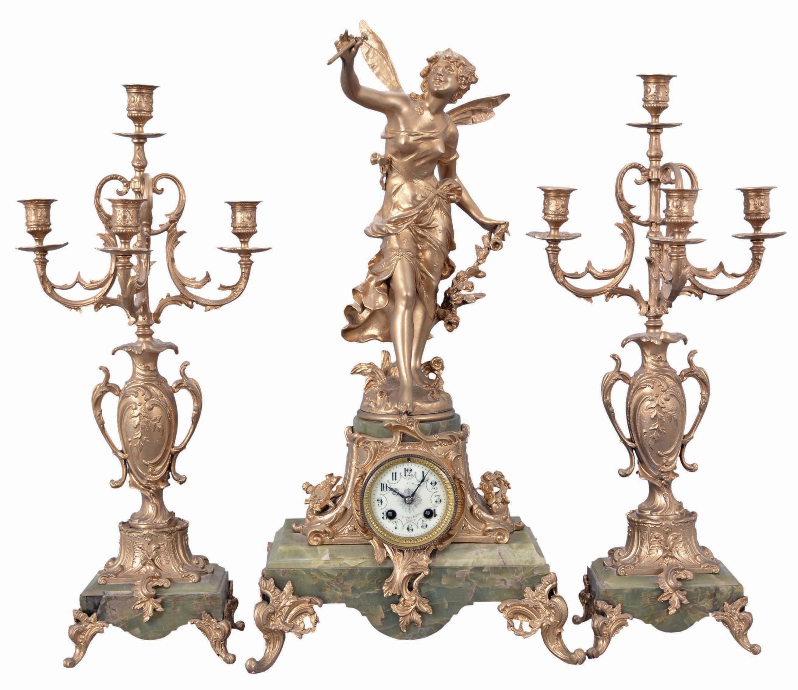 France, three-piece figural mantel clock with garniture, green onyx base on cast rococo feet supporting clock with porcelain dial set within an ornate tapered column, surmounted by a cast spelter female figure with delicate wings. The movement is an 8 day spring driven time and strike pendule de Paris signed by Marti & Cie. Matching onyx and cast metal candelabra hold four candles each. — Antique Clocks Price Guide