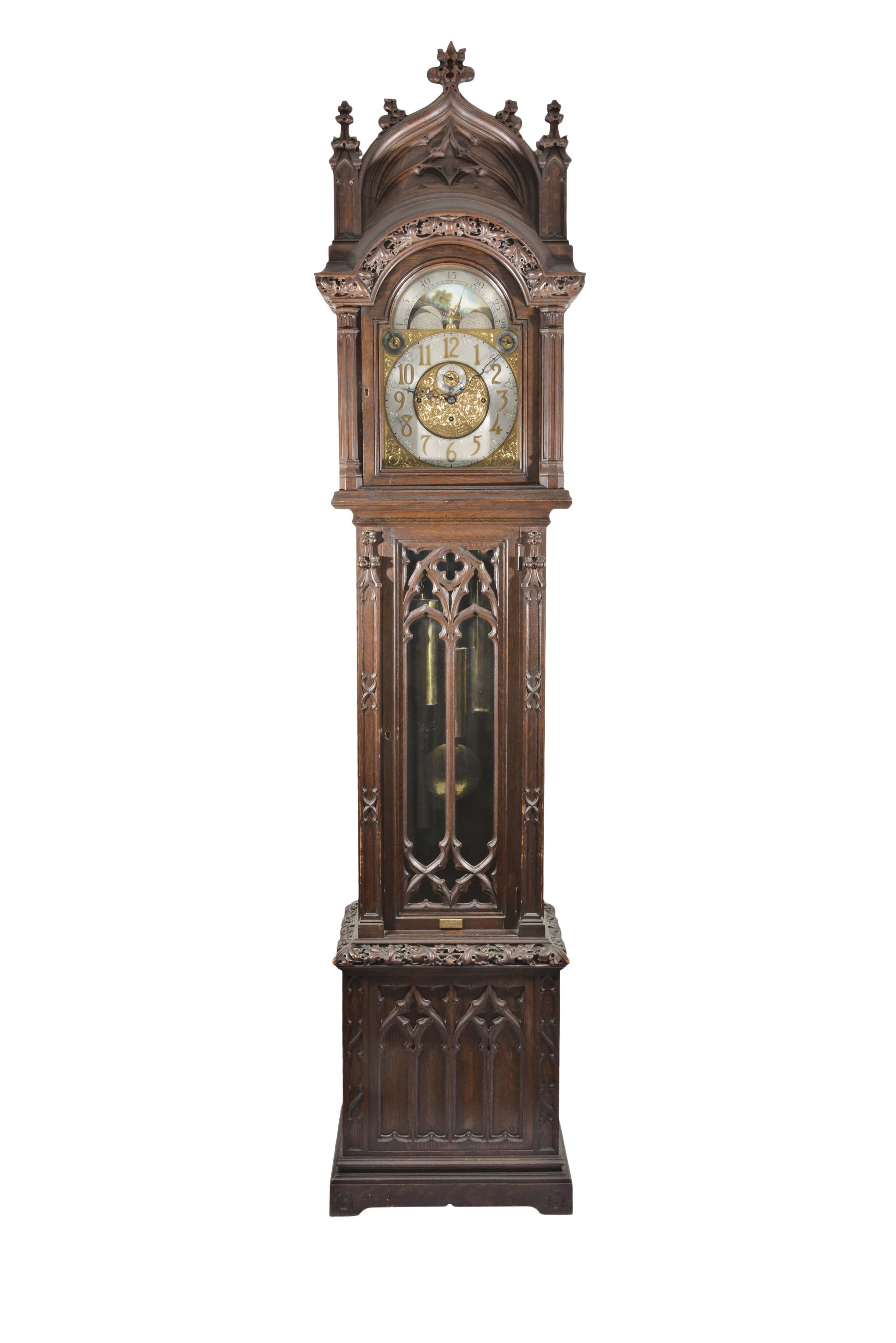 Joseph Jennens, Skideer St, Clerkenwell, London, a monumental oak hall clock in the githic style, 8 day, three train movement playing either Whitington or Westminster chimes on 9 tubes, contained in an elaborately carved oak case. The engraved, composite brass dial silvered chapter ring, chime / silent and tune selectors, seconds bit, and phases of the moon. — Antique Clocks Price Guide