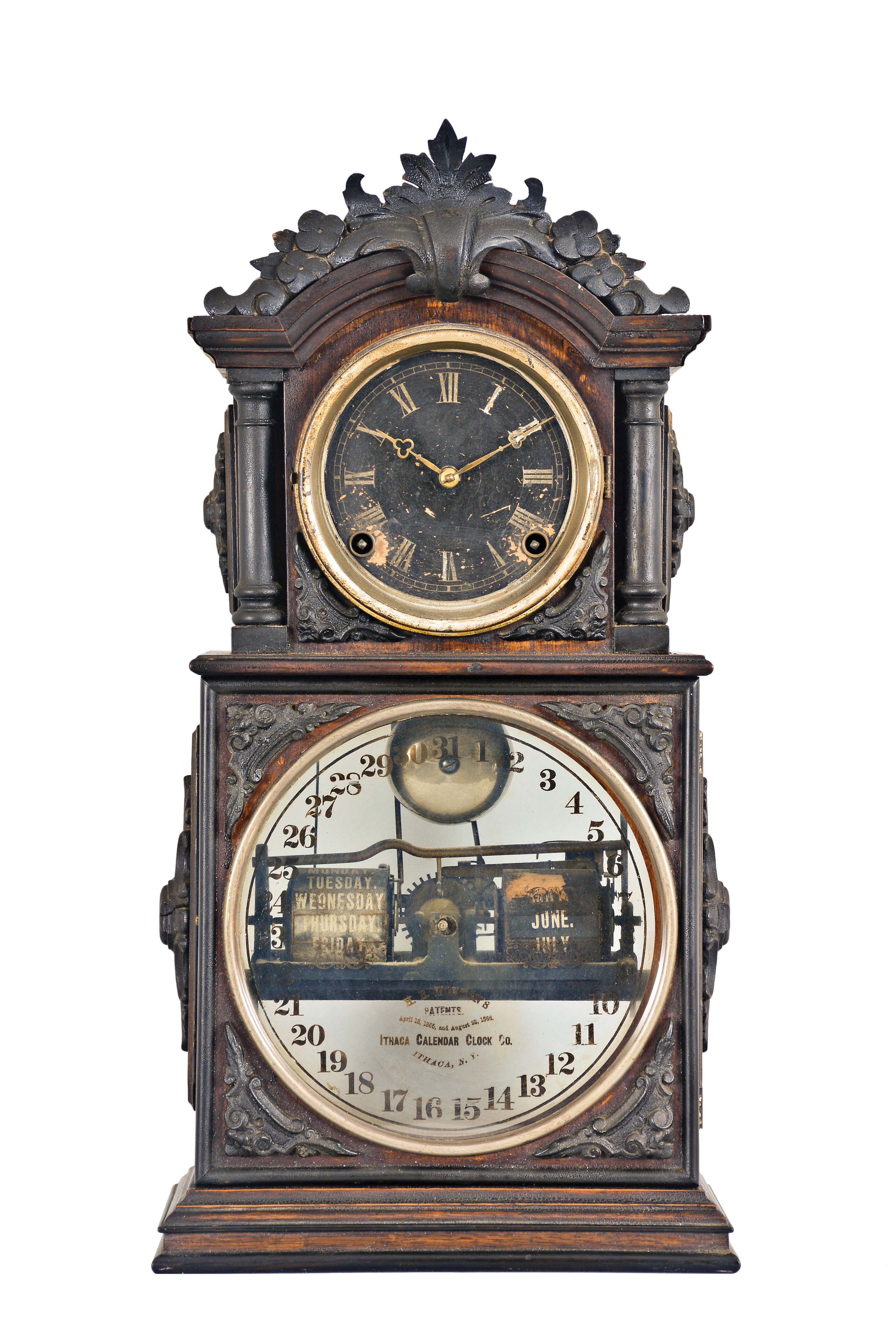 Ithaca Clock Co., Ithaca, New York, "3 1/2 Parlor" Calendar Clock with black and silvered roman numeral dial, tri-foil hands, lower clear glass reveals the glass calendar dial marked "H. B. Horton's Patents...Ithaca Calendar Clock Co./Ithaca, N.Y." with the perimeter in arabic numerals for the day of the month, black rolls with silver days and months set behind with calendar mechanism, eight day time and strike E. N, Welch movement striking on a silvered bell mounted below the movement, walnut case with ebonized composite carving on crest and spandrels, full free-standing columns flank the time dial and bezel, all on a two-stage molded base. — Antique Clocks Price Guide