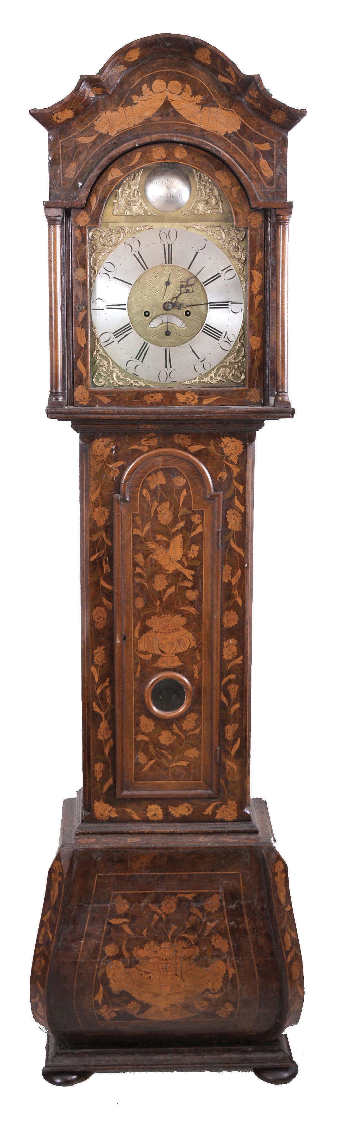 Thomas Watson, Haslingden, England tall clock, 8 day, time and bell strike, weight driven movement now in a Dutch marqueterie veneered bombay style case profusely inlaid with glazed aperture for pendulum bob on bun feet. The brass dial has a silvered chapter ring and silvered maker's boss above 12, cast brass spandrels and silvered calendar disk above 6. — Antique Clocks Price Guide