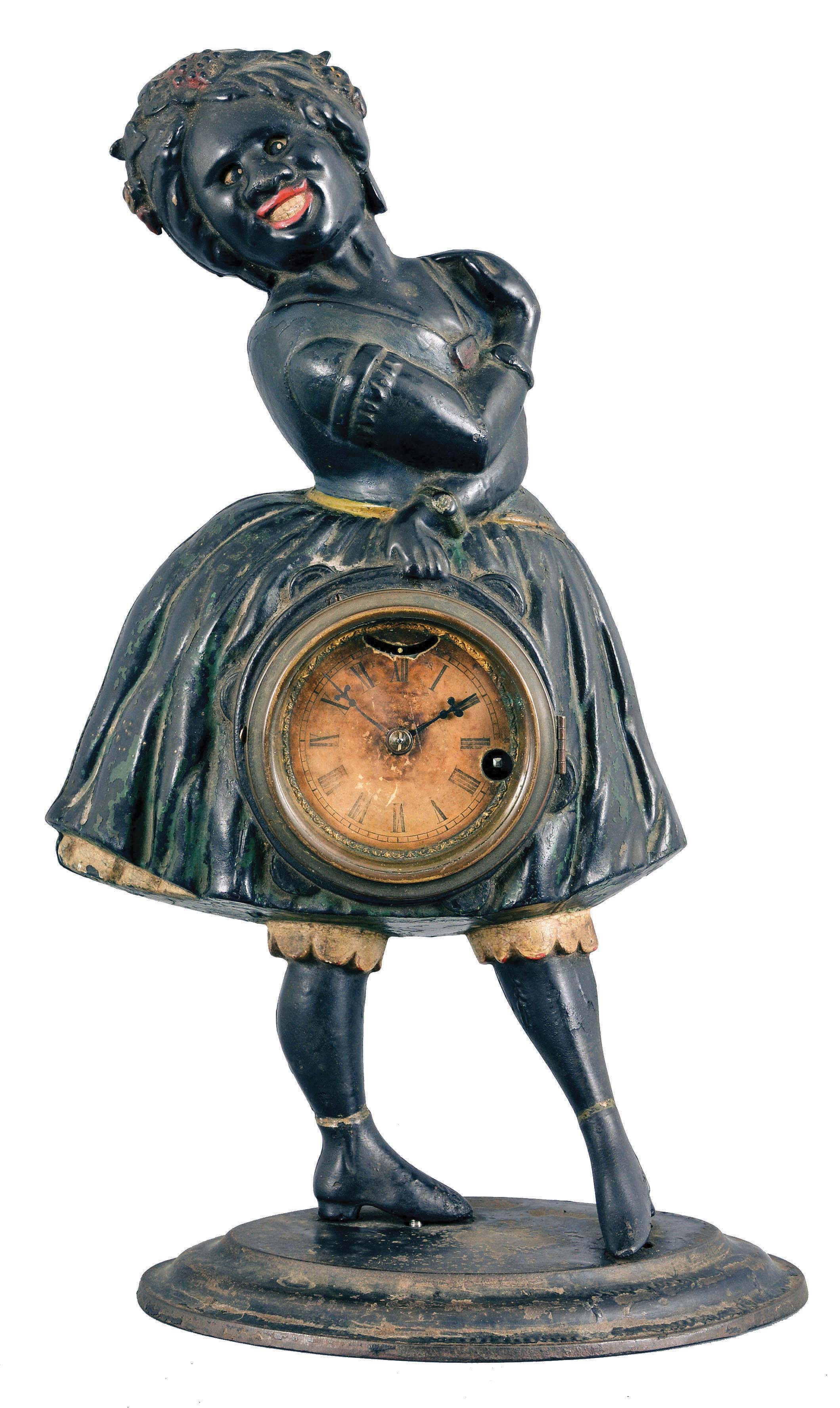 Bradley & Hubbard, Meriden, Conn., for Waterbury Clock Co., "Topsey" blinking eye novelty clock, 30 hour, time and animation, spring driven lever movement in a cast iron case depicting a smiling female figure with dress, blouse, stockings and shoes, 3 inch paper dial with Roman numerals. — Antique Clocks Price Guide