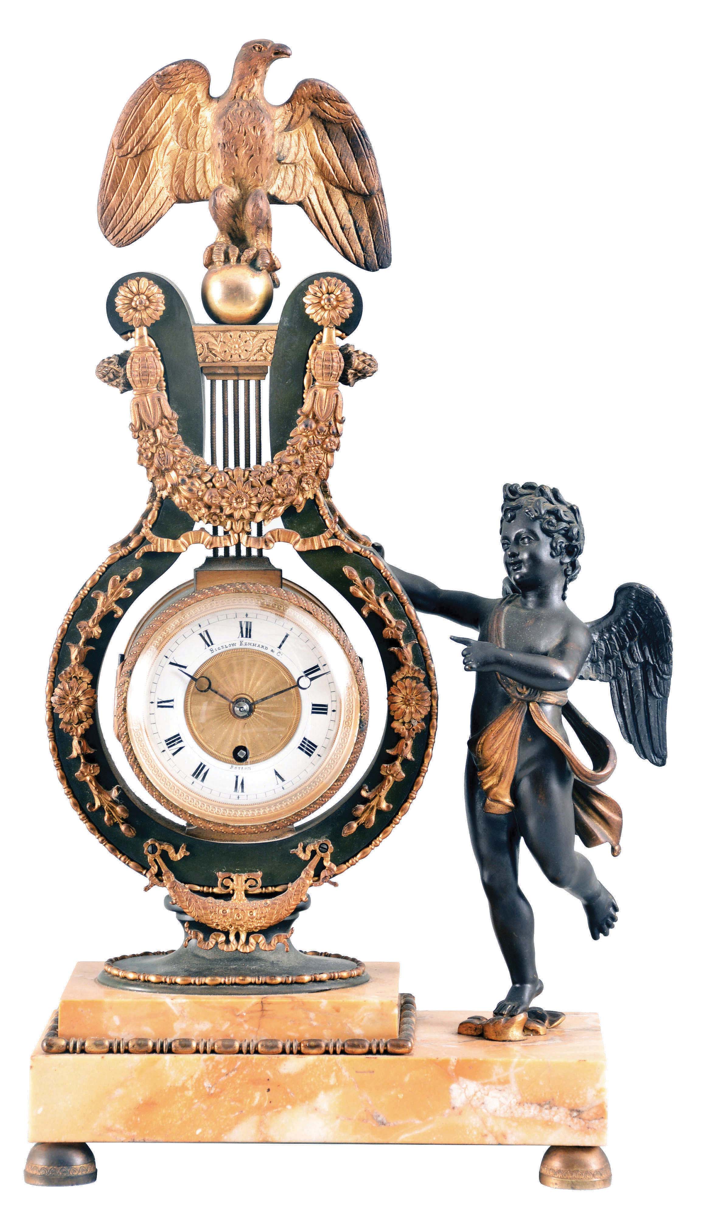 France, for Bigelow, Kennard & Co., Boston, a sienna marble, gilt and patinated bronze mantel clock, the stepped stone base on gilt feet and supporting a patinated lyre form clock with gilt, naturalistic ornament, surmounted buy a gilt eagle finial, and with flanking, patinated putto gesturing toward the timepiece, Roman numeral white enamel dial with engine turned center, blued steel Breguet style hands, 8 day timepiece movement with lever platform and cut bimetallic balance — Antique Clocks Price Guide