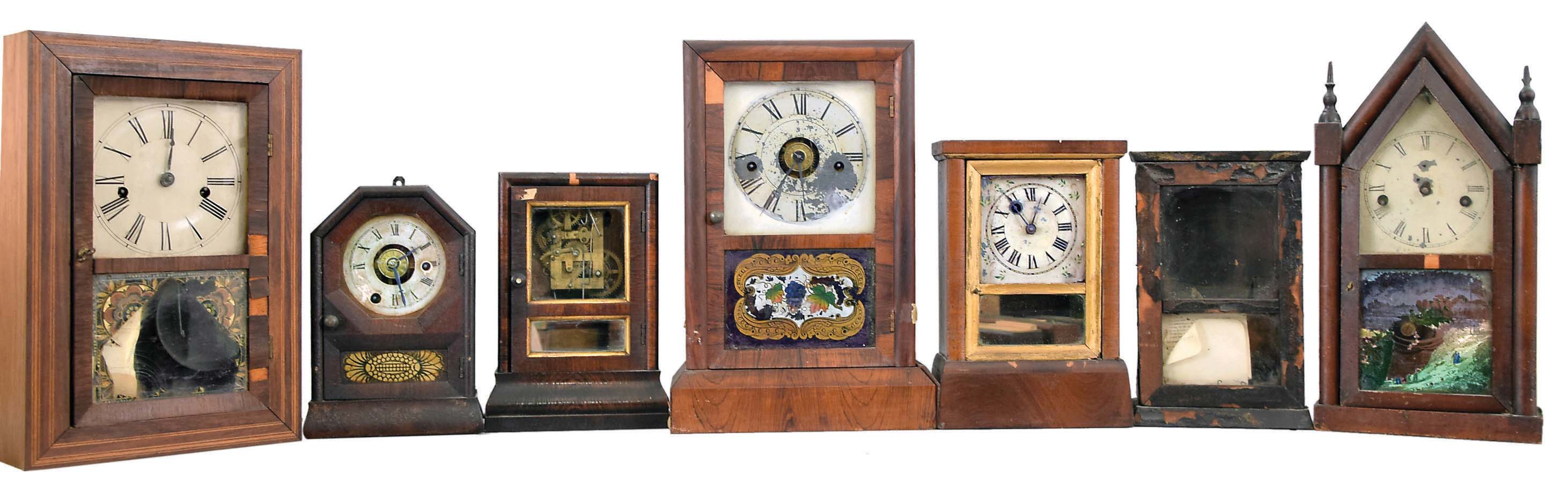 Clocks- 7 (Seven): (1) Elisha Manross, Bristol, shelf clock with a spring driven 30 hour time and strike movement in a rosewood veneered case with inlay, c1850; (2) Seth Thomas, Plymouth Hollow, Conn., cottage shelf clock with a spring driven 30 hour time and alarm movement in a rosewood veneered case, c1850. (3): Brewster & Co., Bristol, Conn., cottage shelf clock with a spring driven 30 hour time and alarm movement in a rosewood veneered case, c1850. (4) Seth Thomas, Plymouth Hollow, Conn., cottage shelf clock with a spring driven 30 hour time and strike movement in a rosewood veneered case, c1850. (5) Daniel Pratt, Reading, Mass., cottage clock with a spring driven 30 hour timepiece movement in a rosewood veneered case, c1855. (6) S. B. Terry, Terryville, Conn., shelf clock with a 30 hour timepiece movement (incomplete) in a paper finished case, c1850. (7) Waterbury Clock Co., Waterbury, Conn. steeple shelf clock with a spring driven 30 hour time and strike case in a mahogany veneered case, c 1855. — Antique Clocks Price Guide