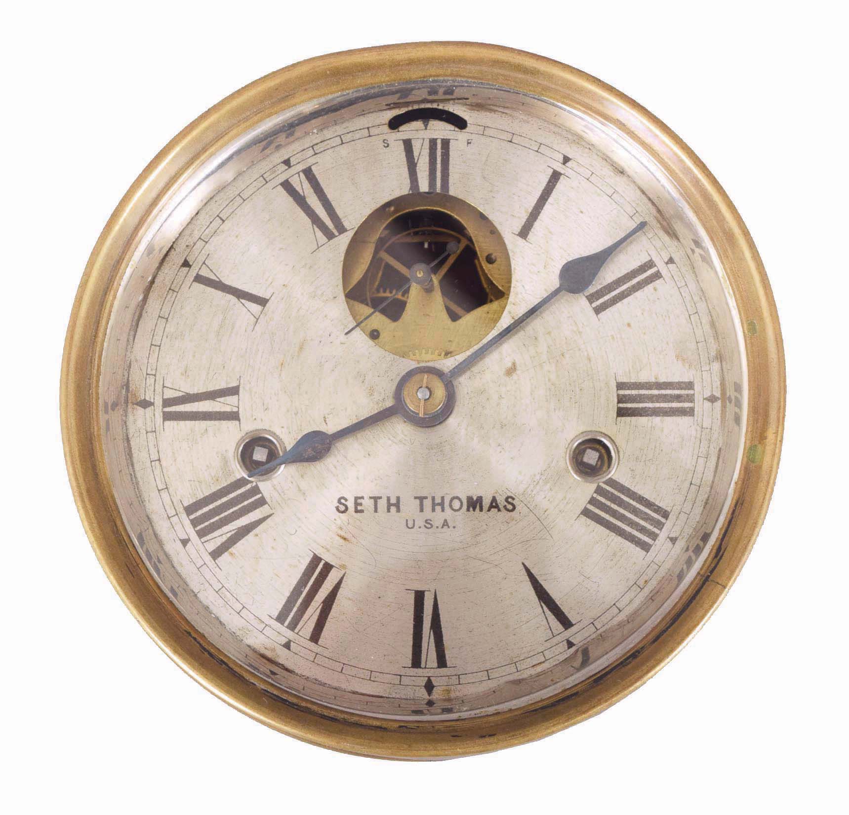 Seth Thomas Clock Co., Thomaston, Conn., 8 day pilot house clock, now with chronometer escapement and one second remontoire, sheet brass case, Roman numeral silvered dial with blued steel hands, brass timepiece movement, now with pivoted detent platform, the original escape wheel replaced with a contrate wheel, and engaging the escape wheel pinion, cut bimetallic balance with overcoil spring and compensation weights, the remontoire controlled by a balance spring, connecting the threaded 12 leaf escape pinion and wheel, with alternate leaves arrested by an adjustable pin in the platform — Antique Clocks Price Guide