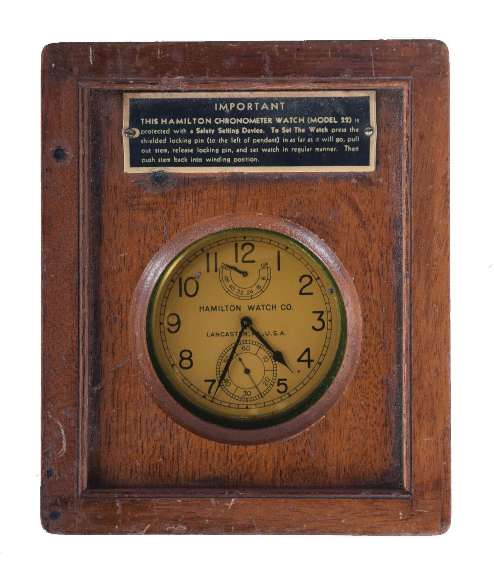 Hamilton Watch Co., Lancaster, Penn., model 22 chronometer watch with wind indicator, 35 size, 21 jewels, stem wind, stem/ pin set, adjusted to 6 positions and temperature straight line damascened nickel plate movement, with lever escapement and micrometric regulator, Arabic numeral silvered, engraved metal dial, black steel spade and poker hands, the timepiece contained in a mahogany box with viewing aperture, serial #2F1907, c1940 — Antique Clocks Price Guide