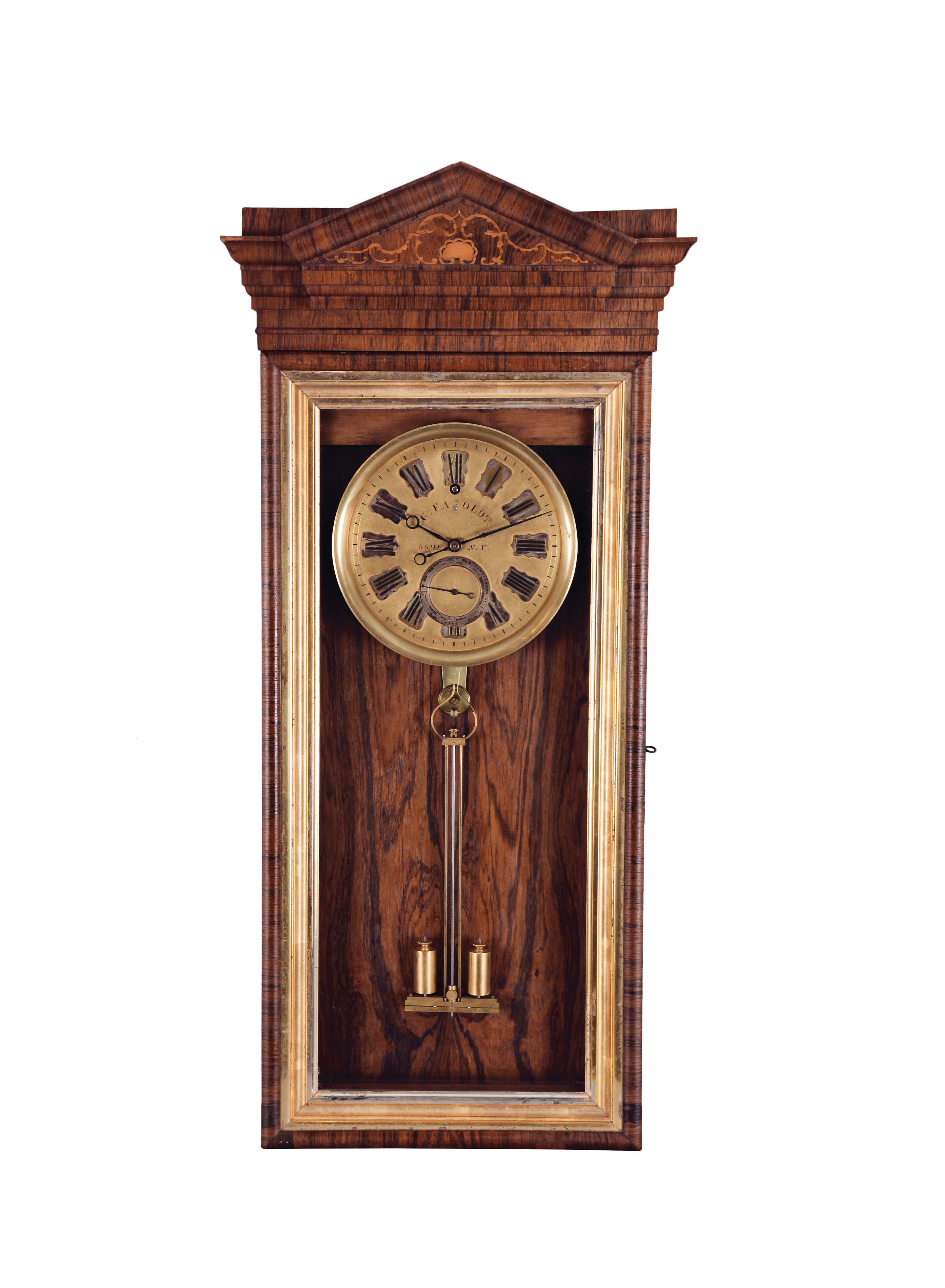Charles Fasoldt, Rome, N.Y., 30 day hanging regulator with escapement constructed to the specifications of his 1859 patent, the rosewood veneered case with architectural, molded top and inlaid, pitched pediment, above a rectangular case with conforming, glazed door and molded, gilt liner, the interior with rosewood veneered weight baffle, matted, gilt brass dial with applied, silvered, Roman numeral cartouches and seconds bit, blued steel hands of Fasoldt pattern, month going, 6 wheel timepiece movement with heavy brass plates, Harrisons maintaining power, and Fasoldt's patent escapement, employing his coaxial escape wheel, bimetallic, compensated pendulum with gilt, adjustable cylinders, and based on Ellicott's design, lead weight with integral pulley, and rosewood handled winding key. — Antique Clocks Price Guide