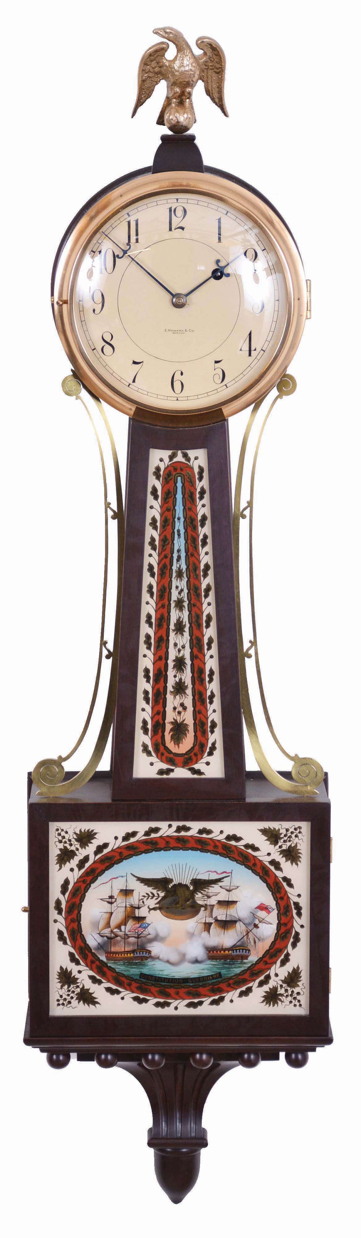 E. Howard & Co., Boston, Mass, "No. 95 Banjo Clock", in mahogany case with eagle finial surmounting the Arabic numeral dial marked "E. Howard & Co./Boston", brass bezel, flat frames for the reverse-paintings on glass, the lower depicting and marked "Constitution--Guerriere" in a blazing War of 1812 battle, a gilt patriotic eagle and banner tops the pendulum viewing port, all enclosed in a red, black and gilt oval cartouche with leafage surround and spandrels, the waist flanked with unusual brass side ornaments features repeating elements and colors set in an oblong border, the base carries a carved pedestal with acorn drop, eight day nickel plate movement marked "E. Howard & Co./Boston" with recoil escapement and viewing ports, maintaining power, and Geneva stop all powered by a lead weight and regulated by a brass faced pendulum bob with flat wooden rod and tie-down. — Antique Clocks Price Guide