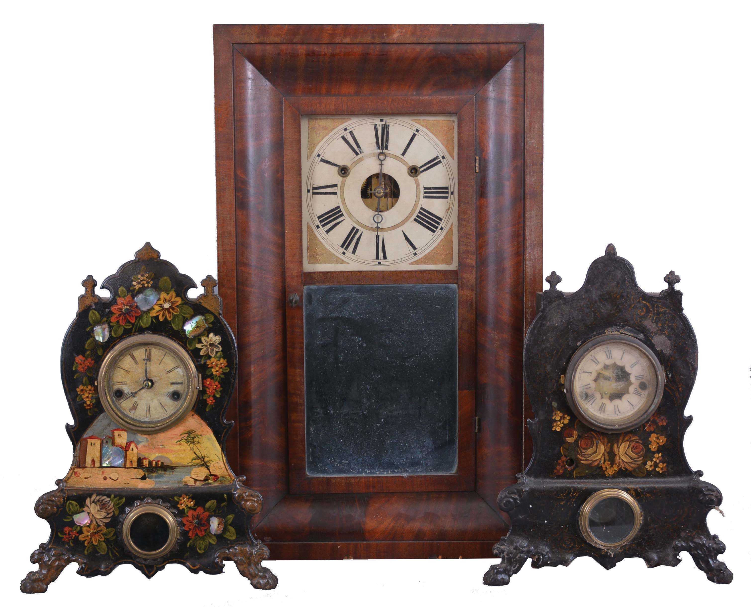 Clocks- 3 (Three) American Shelf: (1) Connecticut, probably Forestville Mfg. Co., Bristol, ogee clock, 30 hour, weight driven time and strike in a walnut veneer case; (2) American Clock Co., New York, iron front shelf clock with 30 hour, time and strike, spring driven movement with a hand painted waterfront scene surrounded by flowers; (3) Waterbury Clock Co., Waterbury, Conn., iron front shelf clock with 30 hour, time and strike with alarm, spring driven movement with a hand painted flowers. — Antique Clocks Price Guide