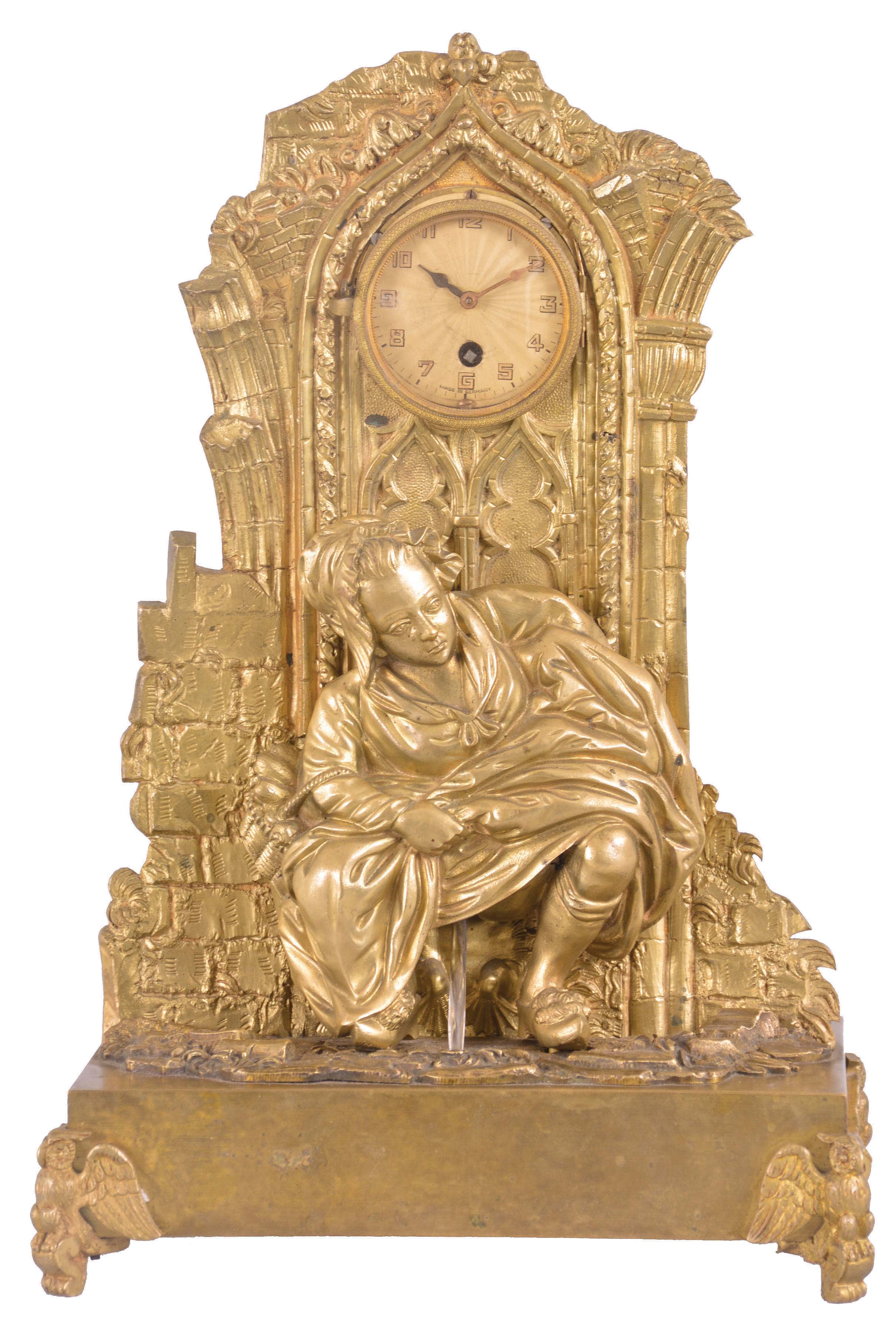 France, an unusual and amusing figural mantel clock, the gilt bronze case with rectangular base on owl form feet, supporting a Gothic ruin with fountain in a rustic landscape, the scene transformed at the observer's will by the placement of the removable, squatting female figure, taking a moment to relieve herself, case back with sheet brass enclosure now with Arabic numeral metal dial and 30 hour timepiece movement — Antique Clocks Price Guide