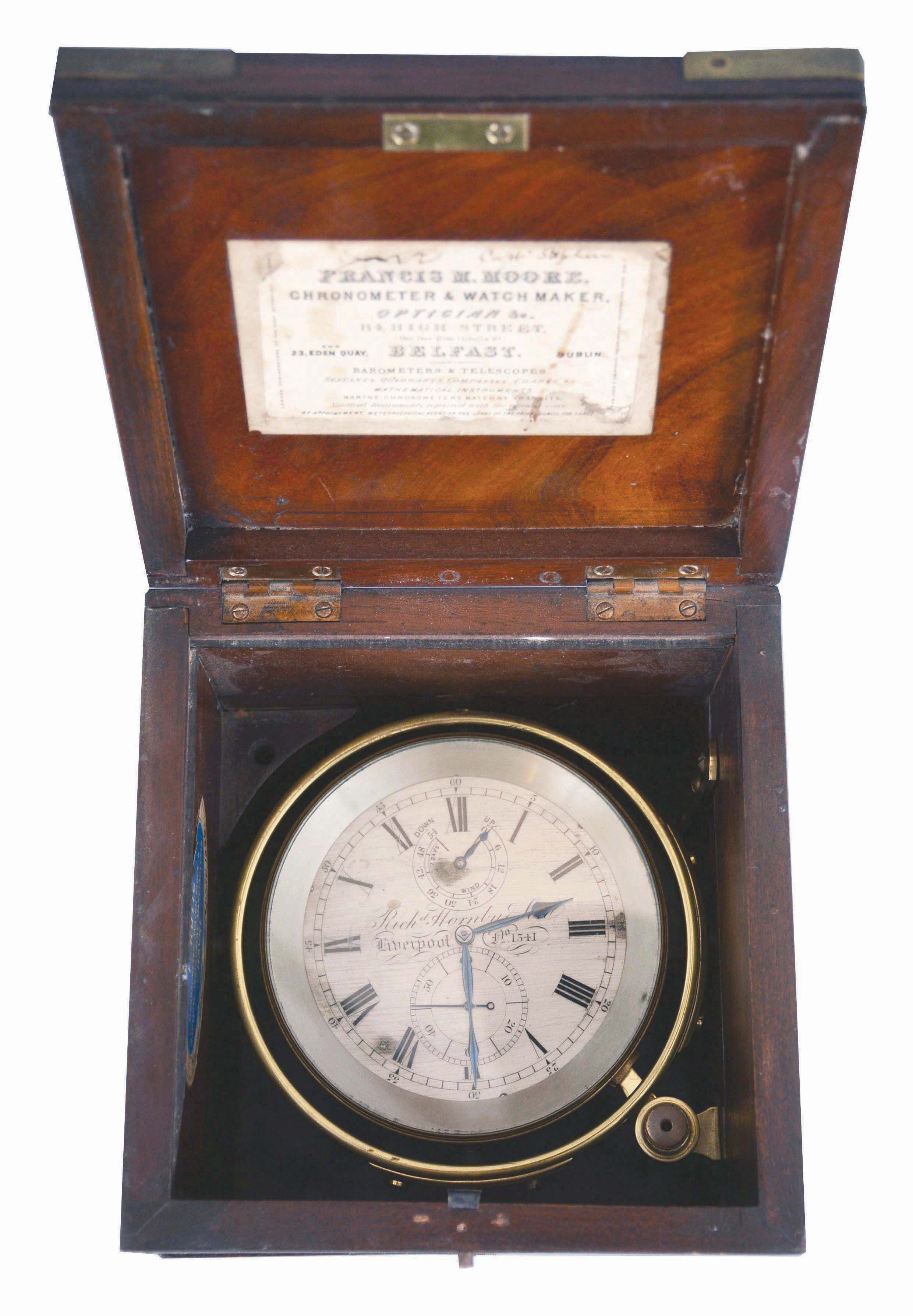Richard Hornby and Son, Liverpool, a two day marine chronometer unusual balance and spring, 11 jewel, free sprung fusee movement with Earnshaw's spring detent, uncut monometallic balance with quarter screws and four cylindrical, adjustable weights and white helical balance spring, Roman numeral silvered dial with wind indicator, blued steel spade and poker hands, contained in a lacquered brass bowl with gimbals, and mounted in a mahogany and mahogany veneer box with brass furniture, serial #1341, and also with labels of Francis Moore, Chronometer and Watch Maker, Belfast, and F. Rotig, Havre — Antique Clocks Price Guide