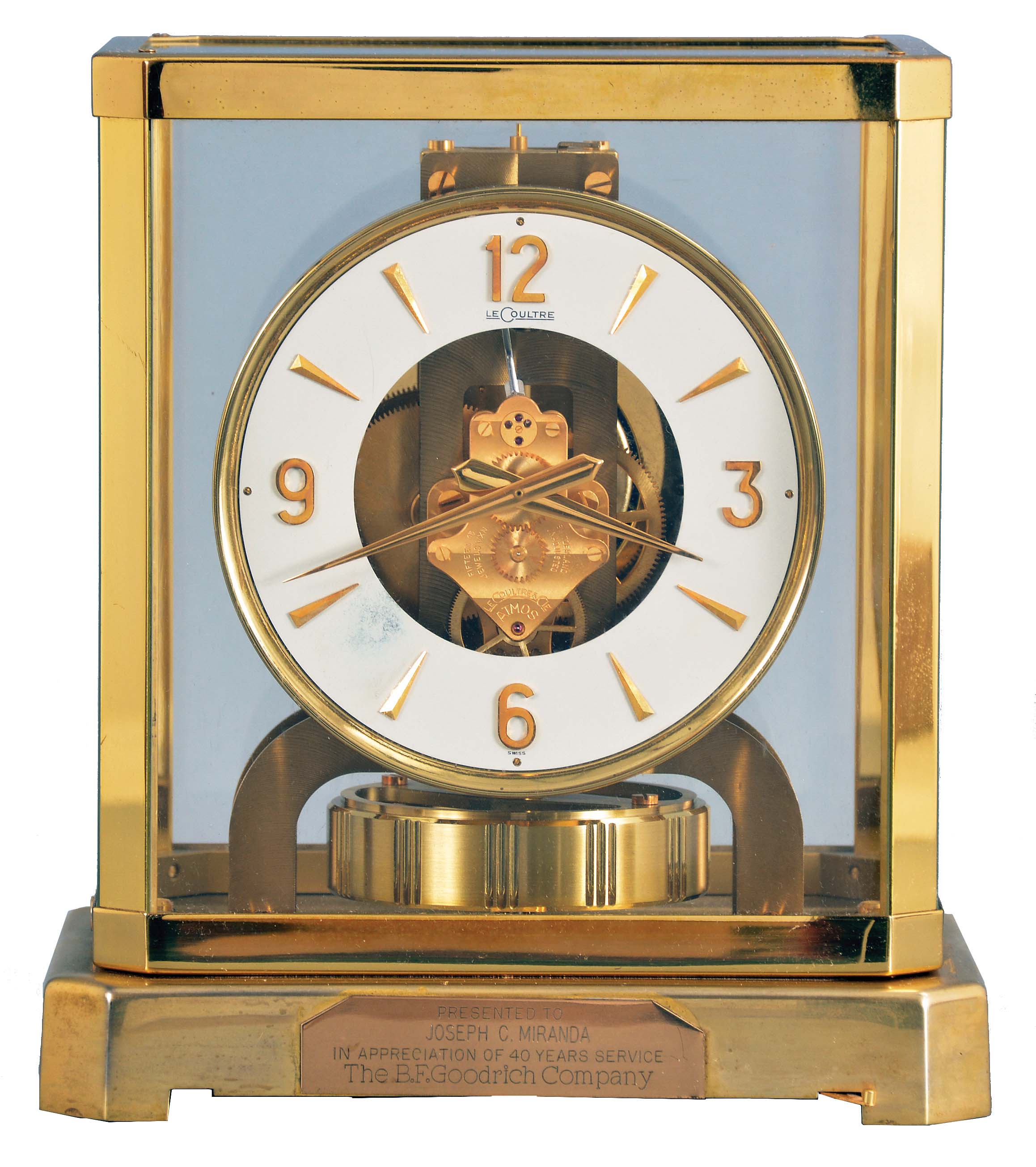 Jaeger- LeCoultre, Switzerland, "Atmos" clock, 15 jewel, caliber 528-8 movement, torsion pendulum, round white painted dial with applied gilt Arabic numerals and arrow markers, gilt hands, all contained in a glazed rectangular case with dedication plaque, serial #212045, c1966. — Antique Clocks Price Guide