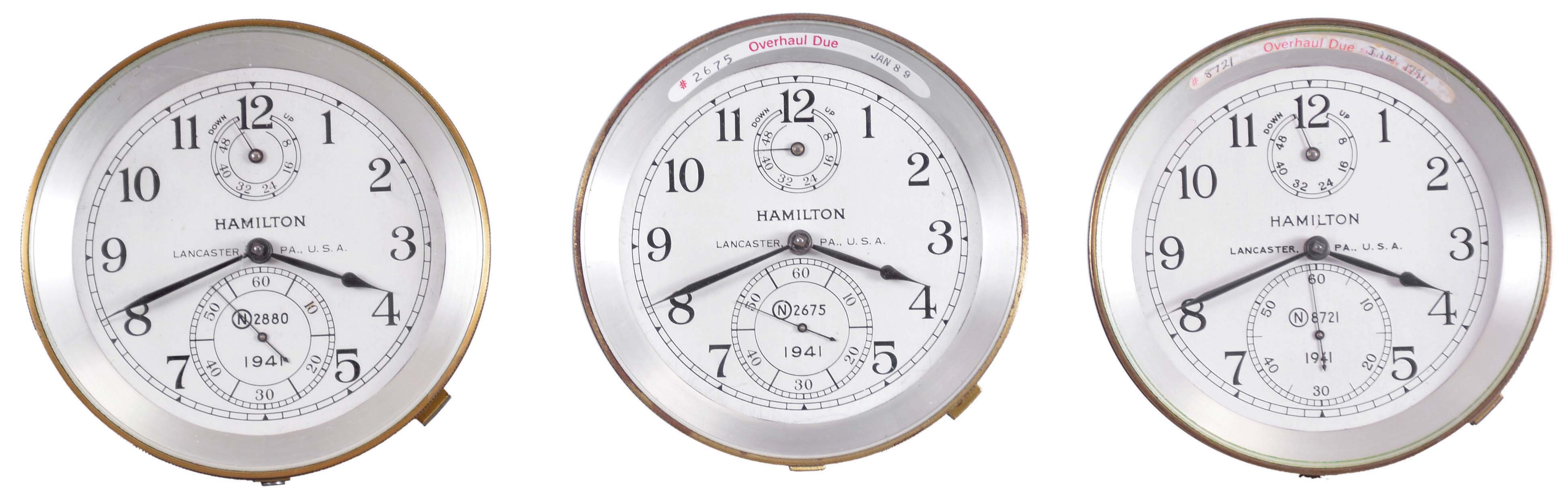 Clocks- 3 (Three) Chronometers Hamilton Watch Co., Lancaster, Penn., model 21 marine chronometers and bowls, 14 jewel, key wind and set, straight line damascened nickel plate movement with spring detent escapement and chronometer balance with helical balance spring, Arabic numerals on silvered metal dial with wind indicator, black painted steel spade and poker hands, serial numbers N2880, N2675, N872. — Antique Clocks Price Guide