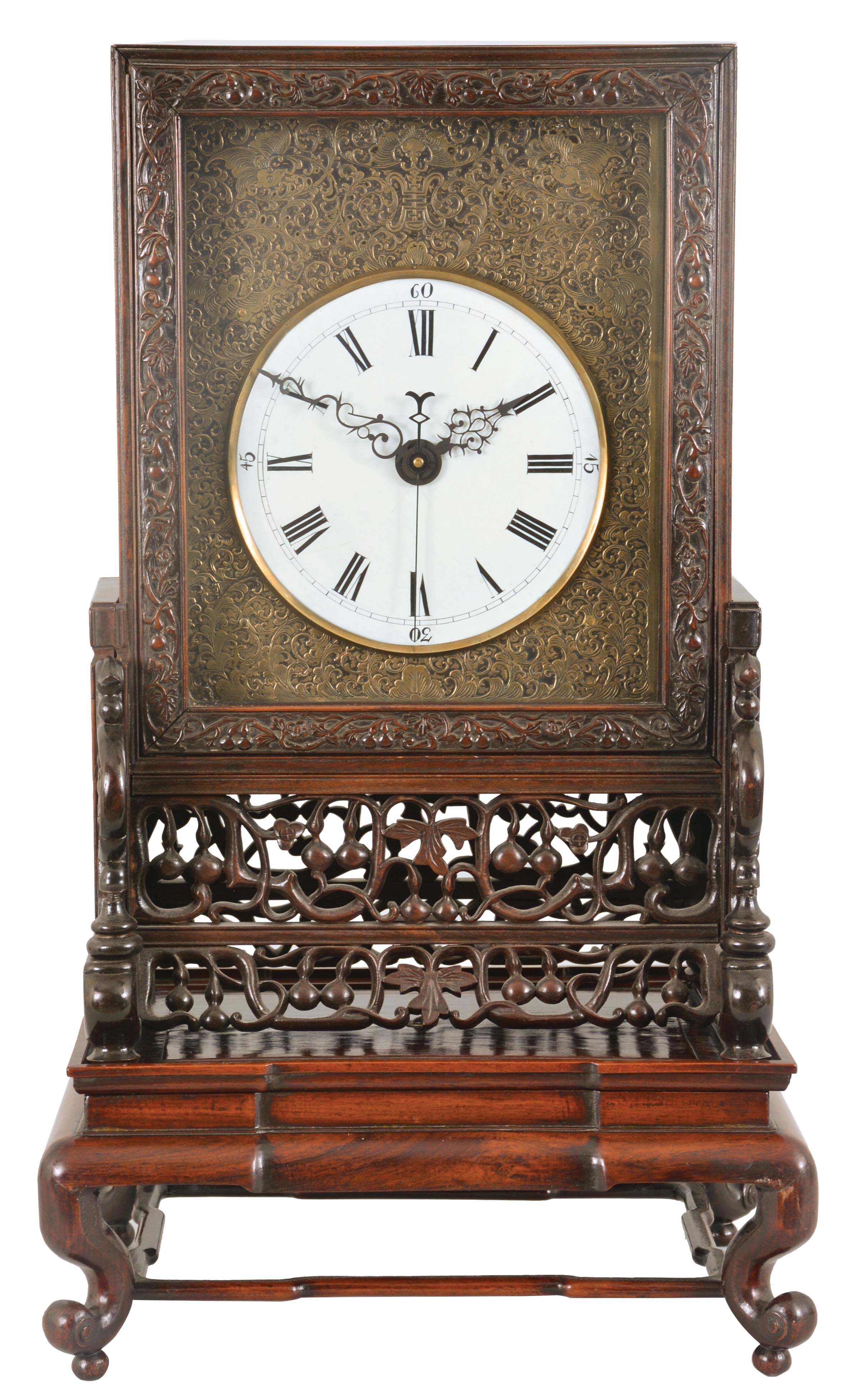 China, a carved camphorwood bracket clock with rotating stand, with pierced and glazed sides, front panel with foliate carving, base with pierced and carved fretwork, Roman numeral white enamel dial with engraved brass surround, blued steel hands, 8 day, time and strike fusee movement with verge escapement, and striking petit sonnerie quarters on two bells — Antique Clocks Price Guide