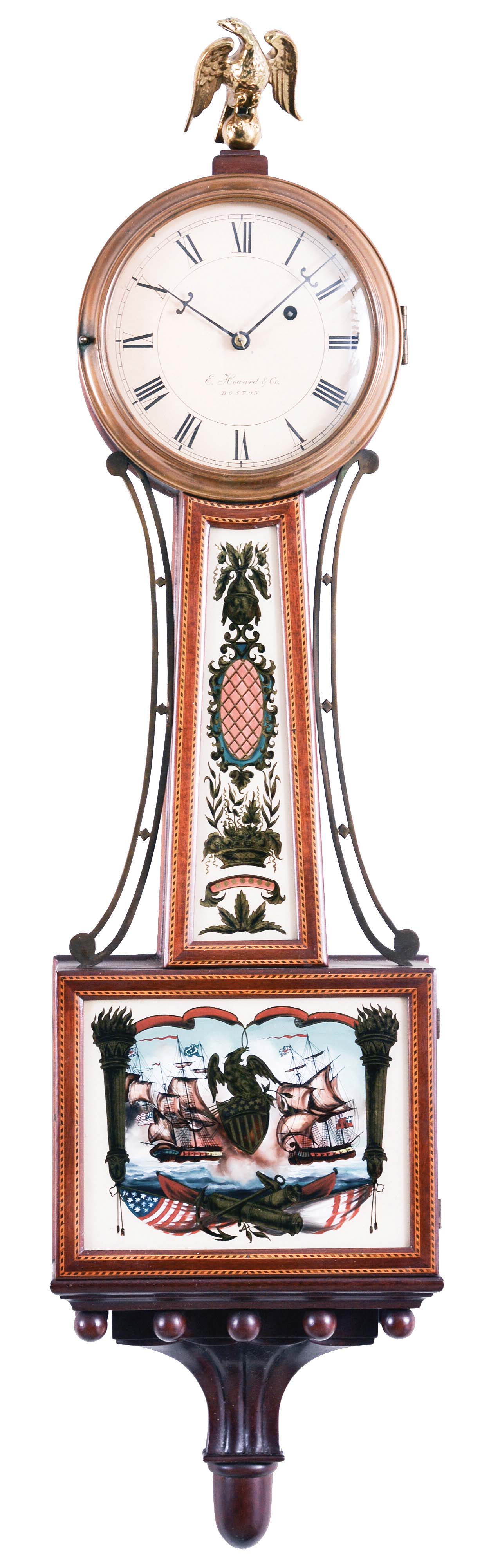 E. Howard & Co. Boston, Mass., "No. 95 Banjo Clock", the special order mahogany case surmounted by a cast brass eagle finial, roman numeral dial signed "E. Howard & Co./ Boston", slightly convex frames with two lines of segmented dark and light inlays frame the superb reverse-paintings on glass, the lower depicting the patriotic scene of American and British war ships (presumably the Constitution and the Guerriere) both flying their national colors set within Patriotic iconography including a draped American flag, canons, an anchor and a central eagle perched on a Federal shield for pendulum viewing all framed by gilt flaming columns, the waist glass flanked by brass side ornaments depicts a floral basket, cross-hatched cartouche and finial with draperies and floral spray, below a carved pedestal with balls and acorn drop, eight day brass weight powered movement stamped "E. Howard & Co./Boston" with maintaining power, Geneva stop and recoil escapement with front plate viewing ports, all powered by a lead weight and regulated by a brass faced pendulum bob and flat wooden rod. — Antique Clocks Price Guide